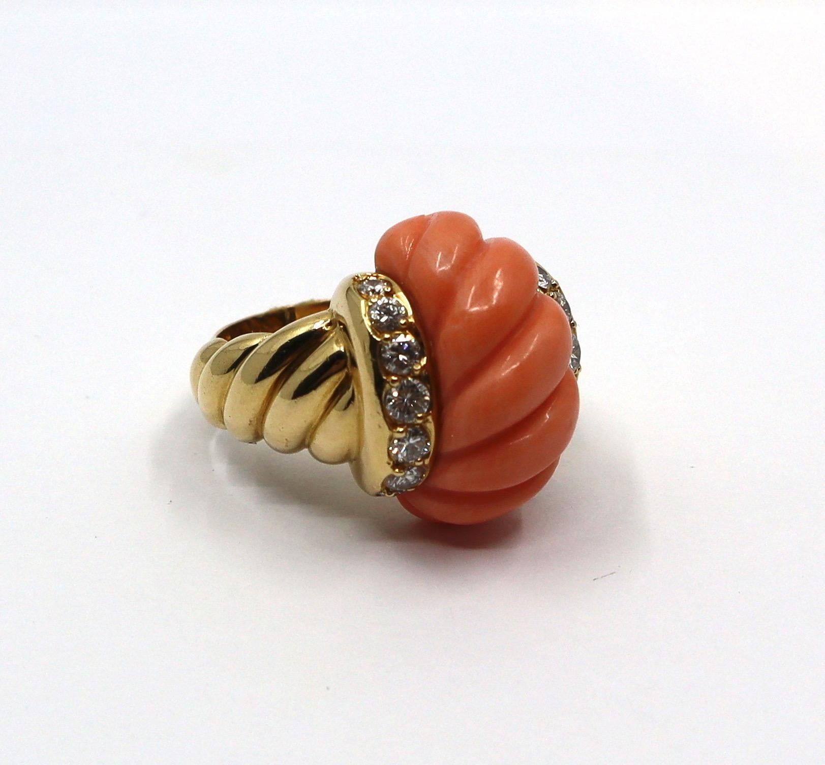Beautiful Van Cleef & Arpels ring in gardooned yellow gold, set with an important carved pink coral surrounded by 14 round cut diamonds. 
Signed VCA and numbered. 
Made in the 60'. 
A rare ring, a typical design from the 60s - 70s, this vintage ring