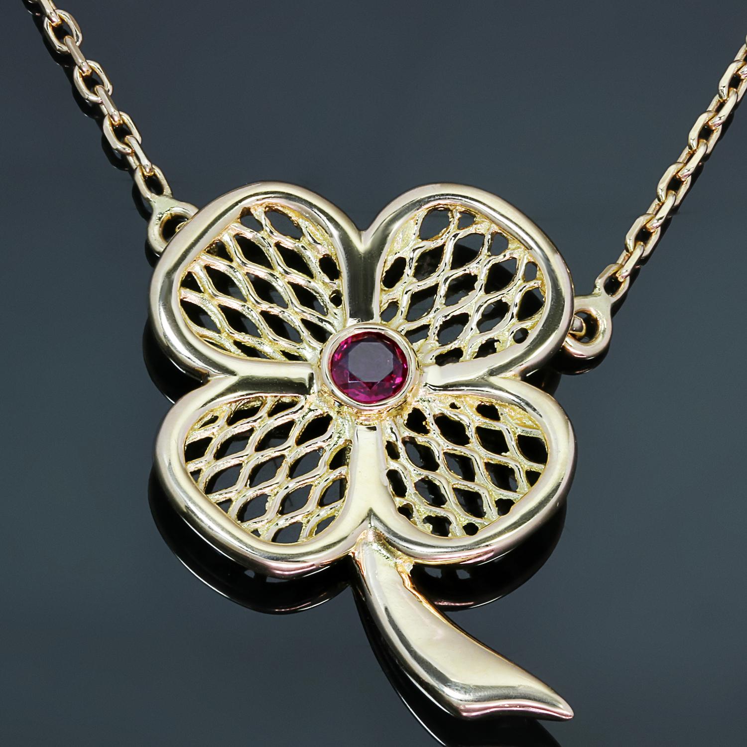 This gorgeous Van Cleef & Arpels necklace features an open lattice 19.0mm x 26.0mm clover flower pendant crafted in 18k yellow gold and set with a round red ruby. Made in France circa 1990s. Measurements: 0.74