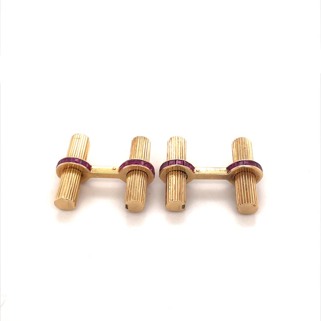Van Cleef and Arpels 14 karat yellow gold baton cufflink set circa 1970.

An outstanding vintage set of baton cufflinks, each featuring a 14 karat yellow gold T-bar terminal which is set all the way round with deep red calibré set rubies.
The T-bar