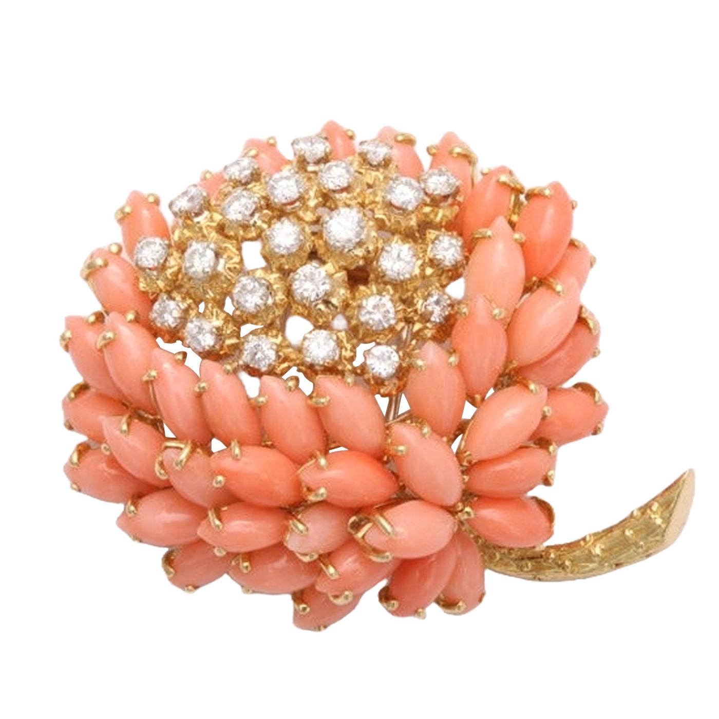 A whimsical Coral and Diamond flower brooch by Van Cleef & Arpels. Consisting of marquise-shaped coral and round diamond weighing approximately 1.75 carats, G color VVS2 quality. Set on 18KT yellow gold. Signed with French