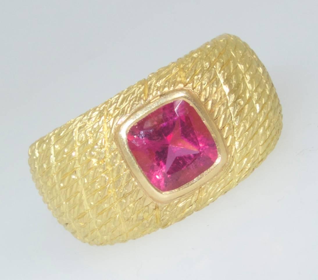  Van Cleef & Arpel, French,  18k ring centering a bright  pink natural tourmaline measures 7.08 by 6.8 by 4.5 mm., and weighing approximately 4.0 cts. This wide Van Cleef & Arpels ring is a size 6.5 and can be sized.  It is signed, numbered and