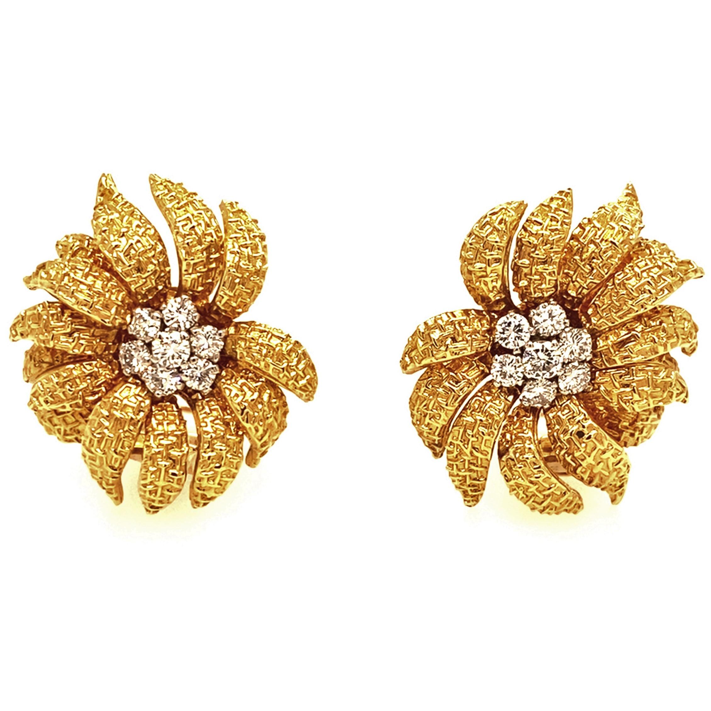 18 karat gold and diamond vintage ear clips by Van Cleef & Arpels.
Glamorous flower earrings featuring finely textured yellow gold petals, each centred by a cluster of brilliant-cut diamonds totalling 1.38 carats. They are completed by 18 karat