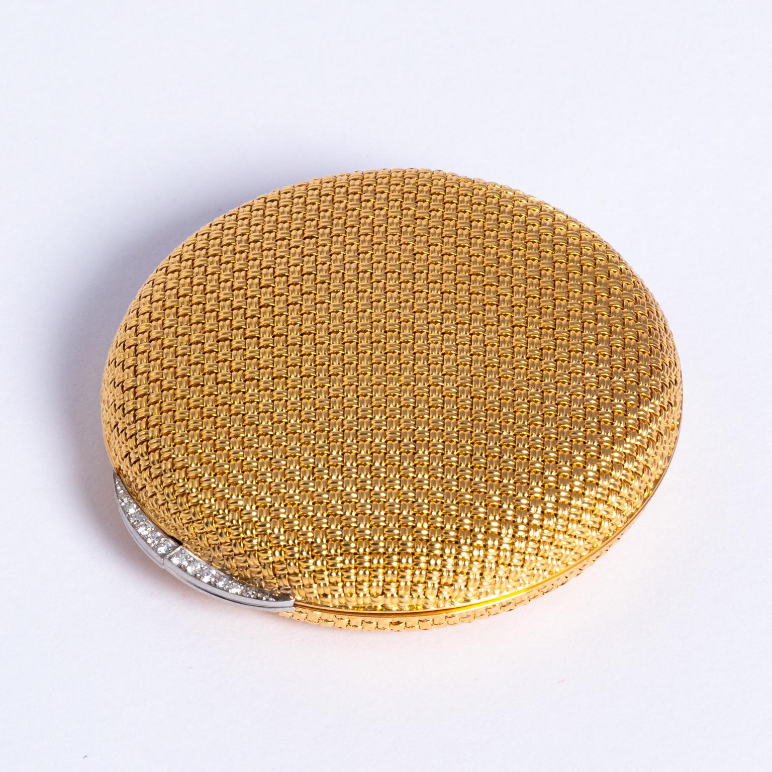 Stunning 1950s 18-karat yellow gold and diamond compact, round shape, with a woven design and a crescent diamond set thumb-piece. Stamped 18K in a shield like mark on the inner ring of the compact, Signed Van Cleef ET Arpels, made in France with a