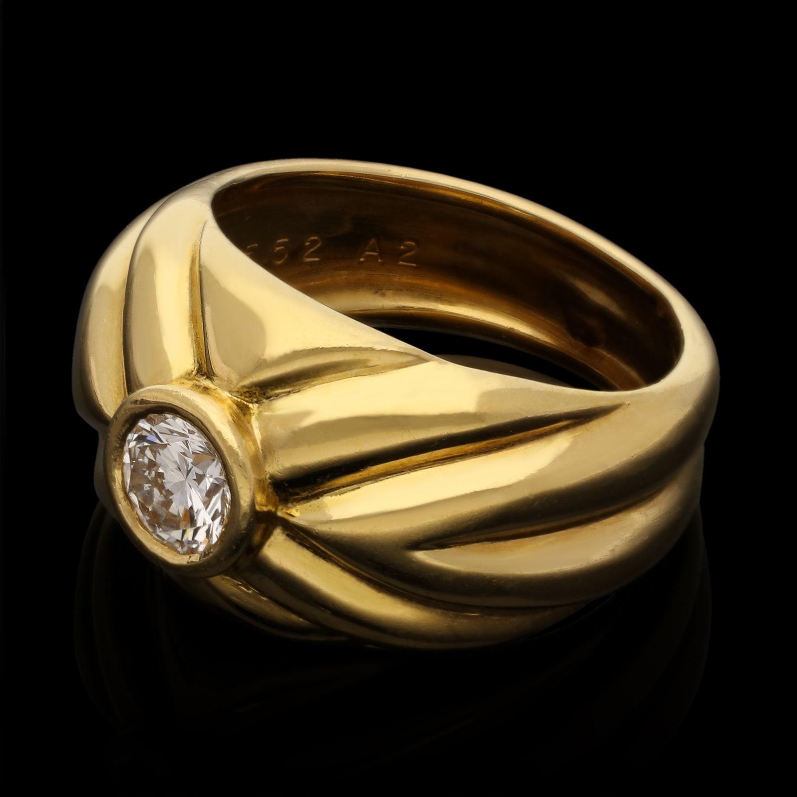 An 18ct gold and diamond ring by Van Cleef & Arpels c.1960s, the domed bombe shape ring in polished 18ct yellow gold has the appearance of fabric that has been pinched together at the centre and then set with a round brilliant cut diamond in bezel