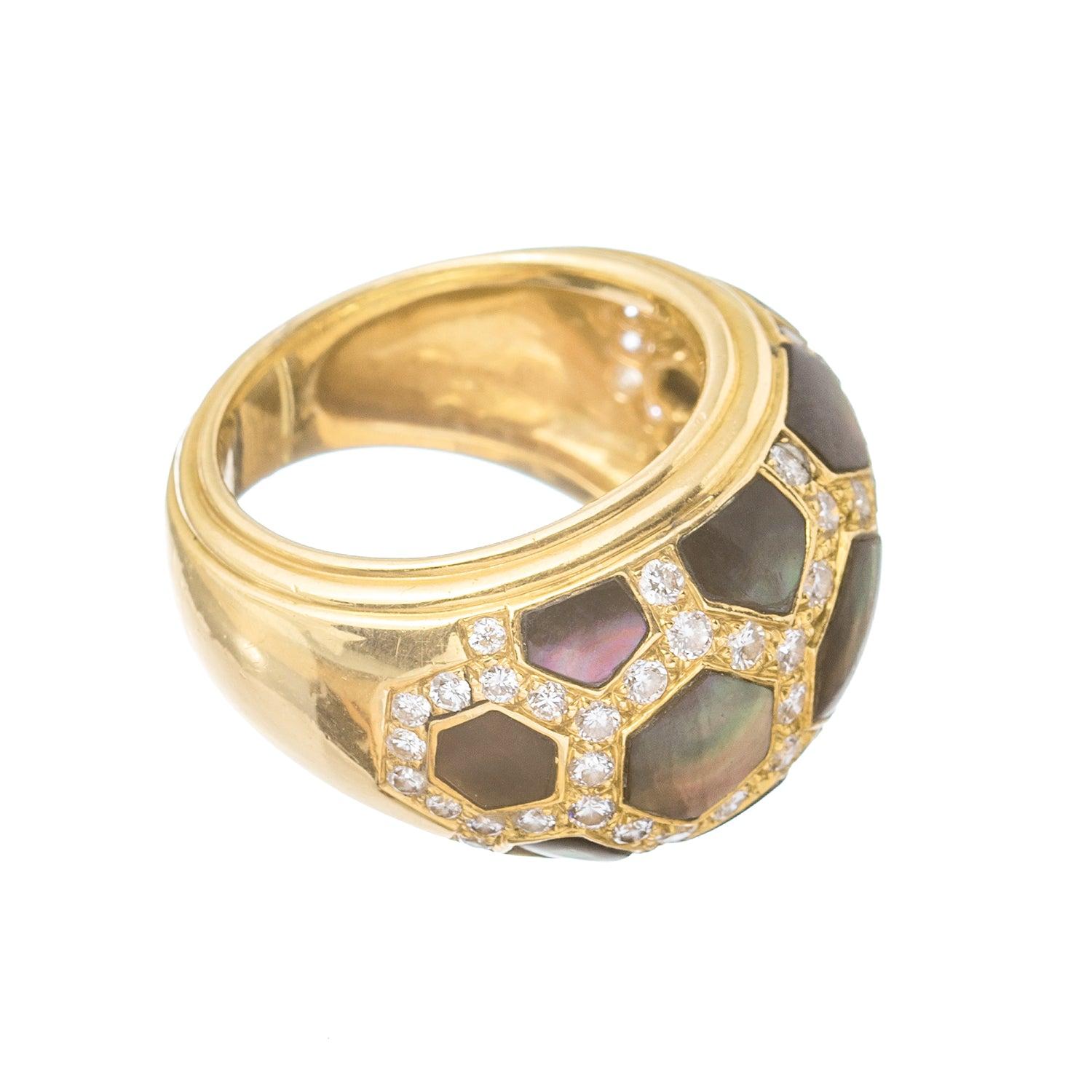 This exquisite Van Cleef & Arpels 18 karat gold domed band ring showcases a unique honeycomb pattern, adorned with stunning inset abalone, and framed by round brilliant-cut diamonds.

With its signature 
