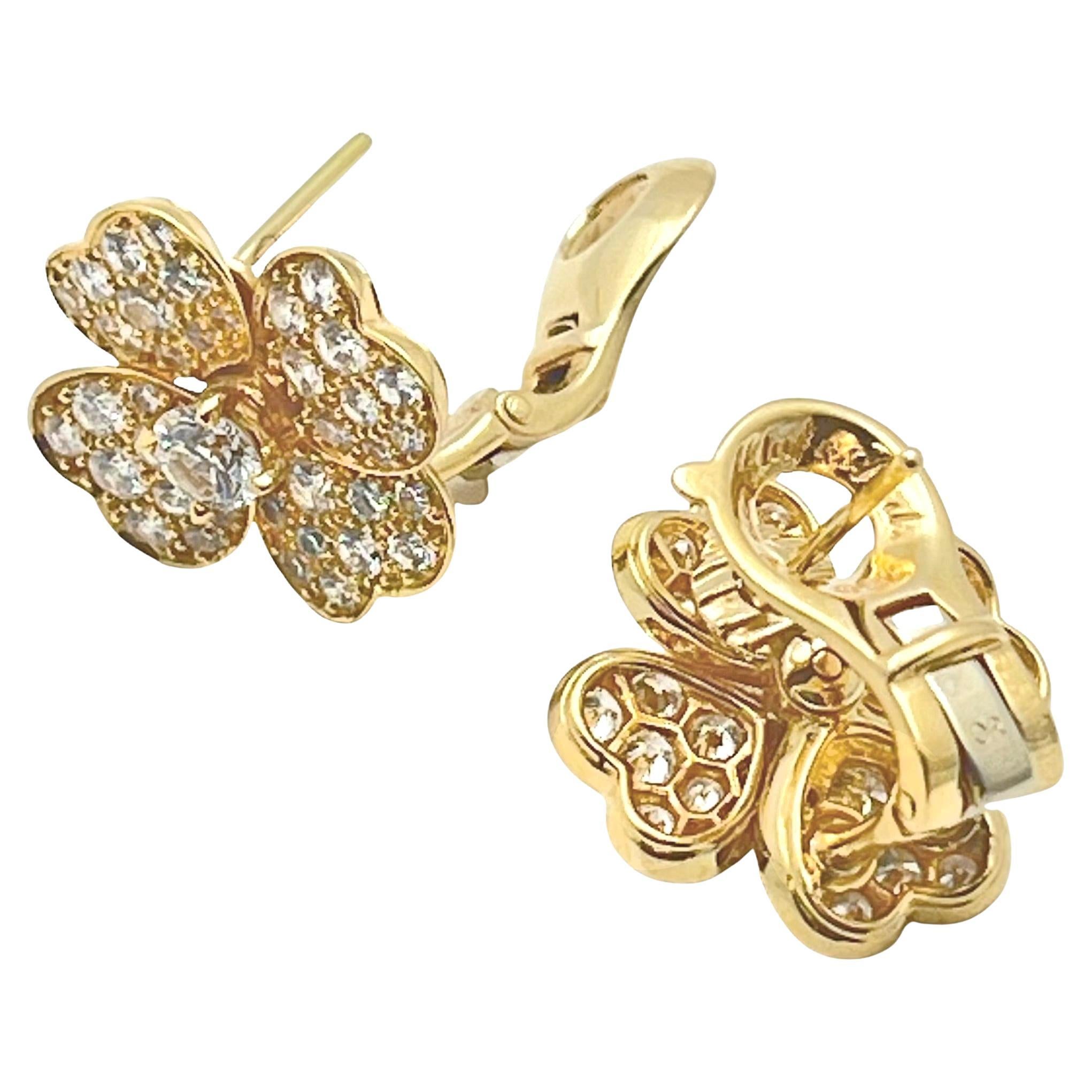 Van Cleef & Arpels iconic Cosmos flower earrings in 18k yellow gold with diamonds.  Each having a larger central round brilliant-cut diamond, surrounded by four petals pave-set with smaller round brilliant-cut diamonds.  80 diamonds weighing