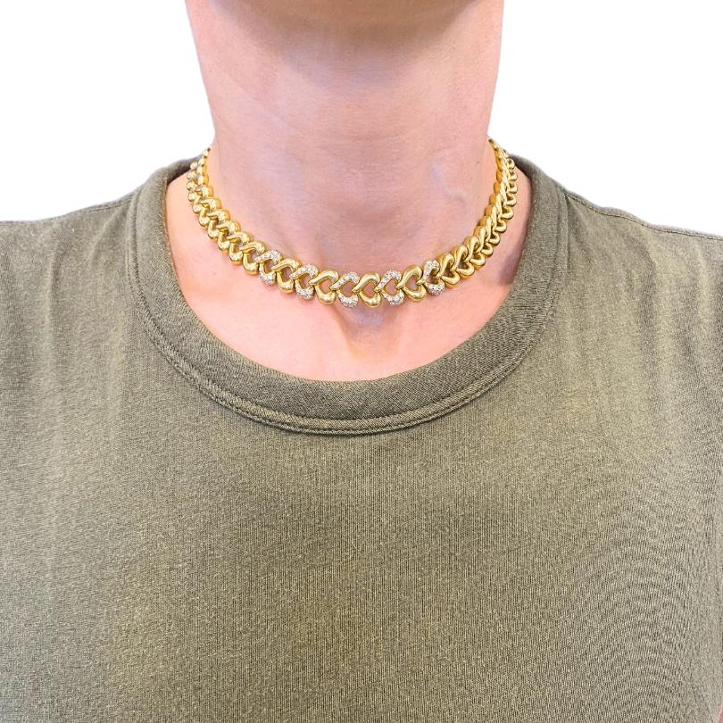 Ce collier Van Cleef & Arpels en or 18 carats et diamants est fabriqué en or jaune 18 carats et présente une série de maillons en forme de cœur, dont certains sont sertis de diamants. Les maillons sont ajourés et le fermoir est orné d'un joli petit