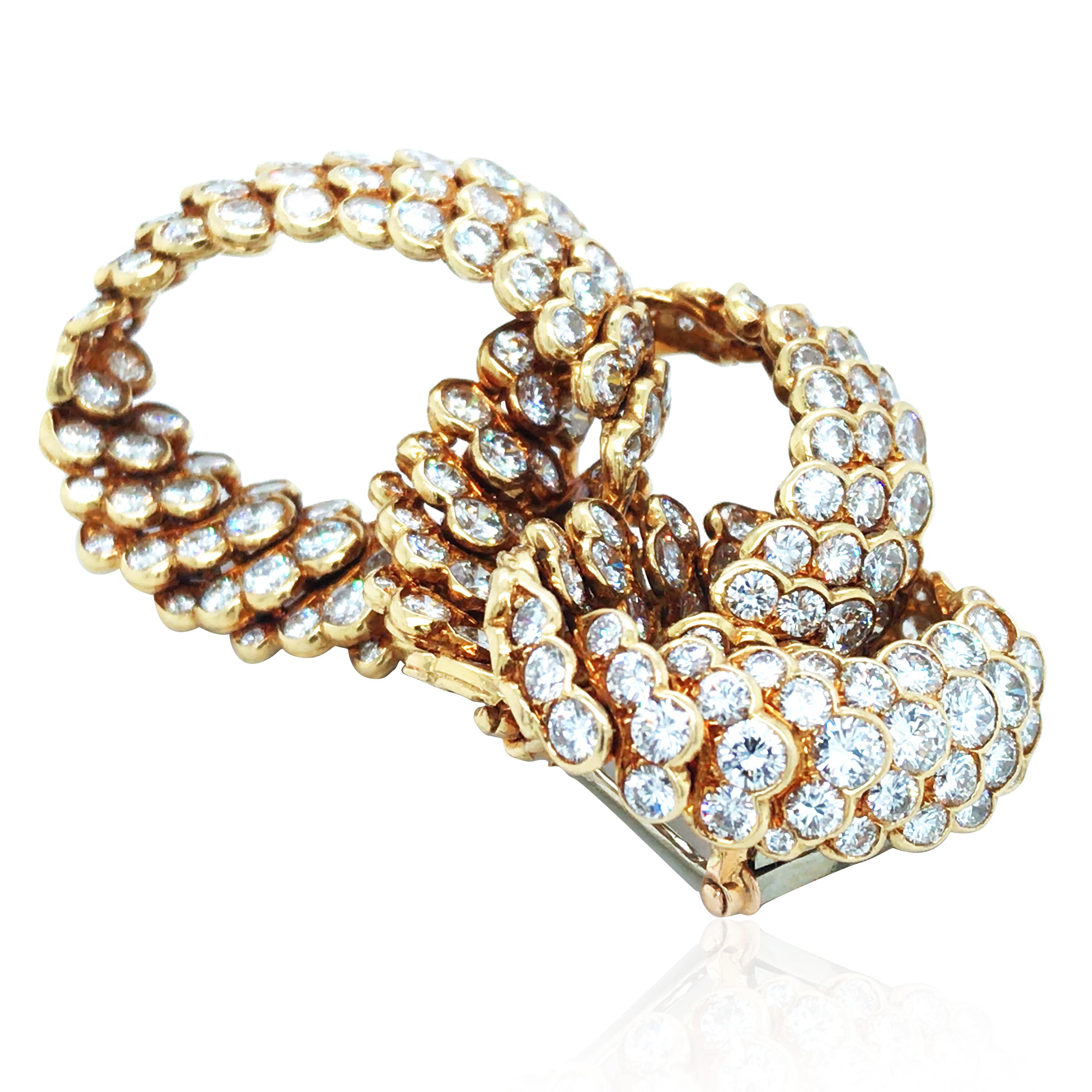 Questa squisita spilla con diamante in oro 18 carati di Van Cleef & Arpels è caratterizzata da linee fluide e aggraziate, con un design elegante e raffinato. Incastonata con circa 12,1 carati di diamanti scintillanti, delinea perfettamente la forma