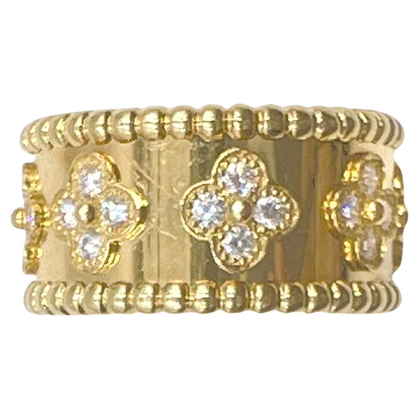 Van Cleef & Arpels medium-sized Perlée ring in polished 18k gold with beaded borders accented by eight mini clover cluster motifs set with thirty-two round full-cut diamonds weighing approximately 0.71 total carats (E-F color, VVS1-VVS2 clarity). 