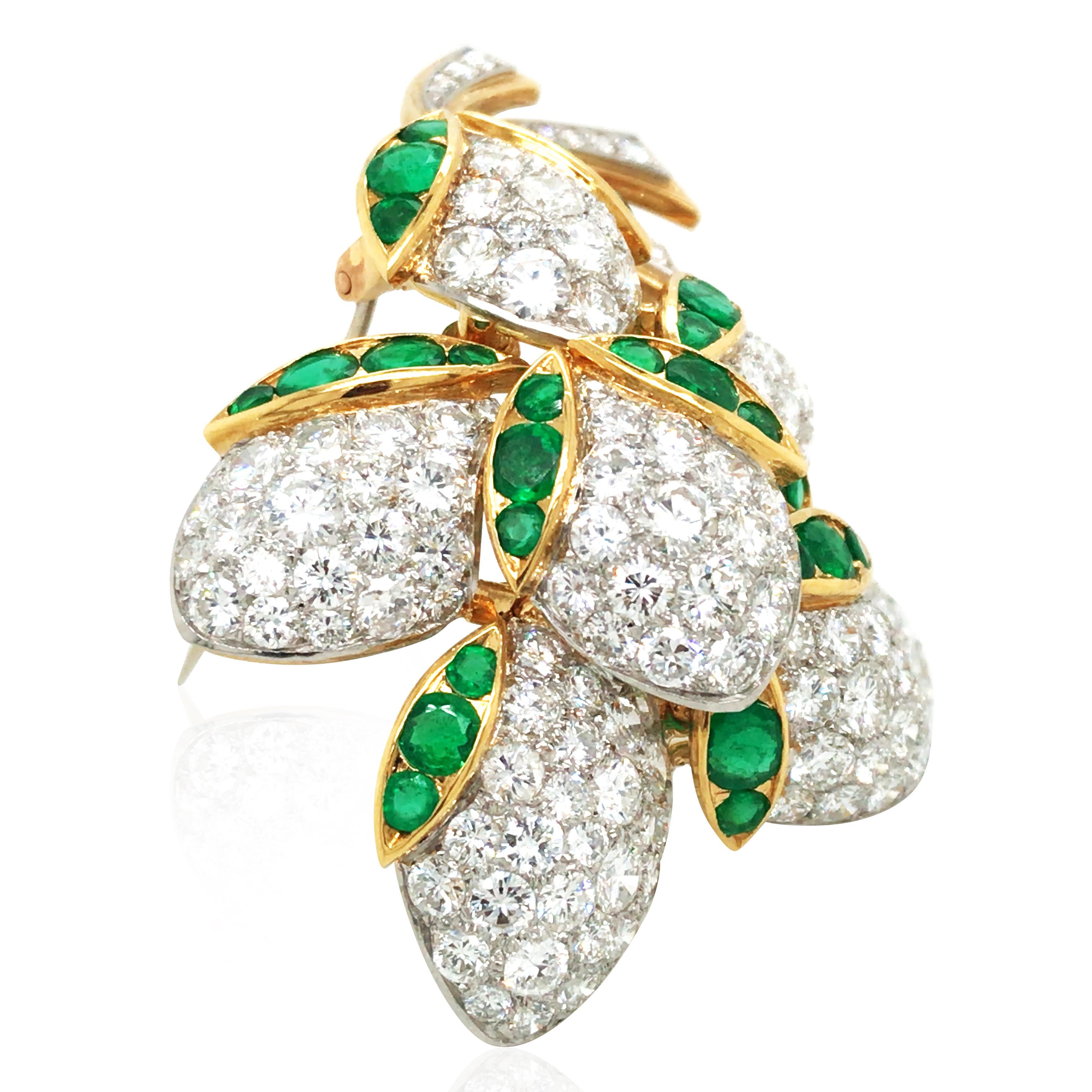 Cette broche Van Cleef & Arpels est d'un éclat exquis, avec des diamants étincelants qui ornent les émeraudes vertes luxuriantes, rayonnant d'élégance et de luxe. Réalisée en or 18 carats, la broche comporte environ 8 carats de diamants et 2,75