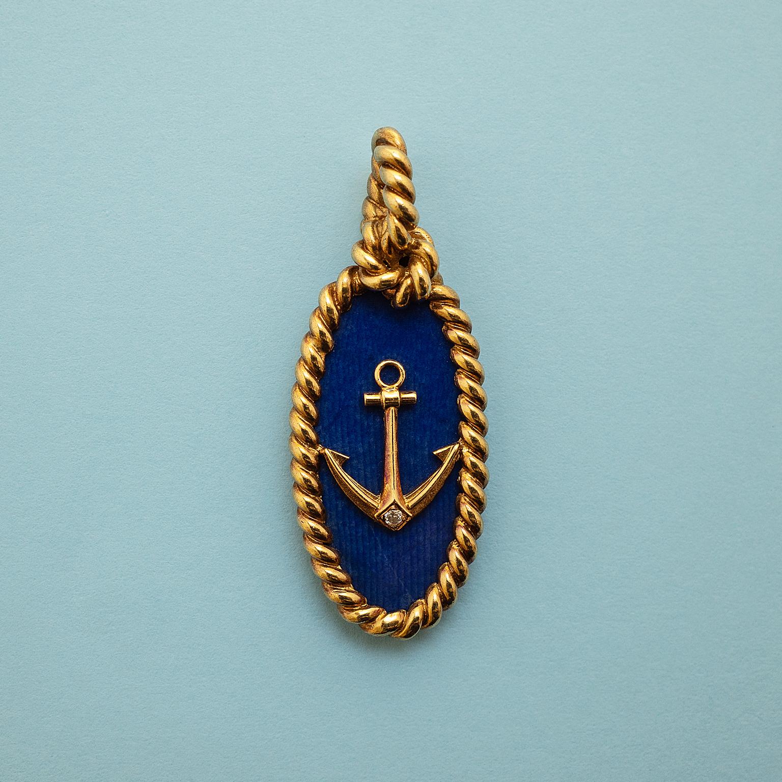 A nautical pendant of a gold and diamond anchor on a slab of sodalite with a border and bail or twisted gold knotted as a rope, signed and numbered, Van Cleef & Arpels, circa 1970.

length: 4.5 cm.