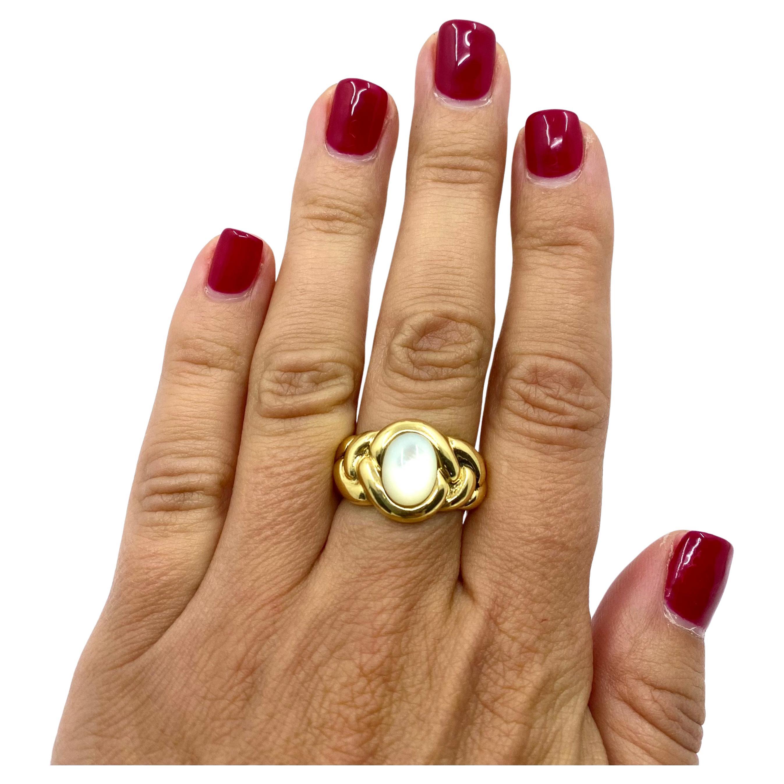 A beautiful vintage ring by Van Cleef & Arpels made of 18k gold and mother of pearl. The ring is designed as a braded shank that frames the oval cabochon cut mother-of-pearl. This VCA ring’s design is sensual and feminine. The smooth lines of the