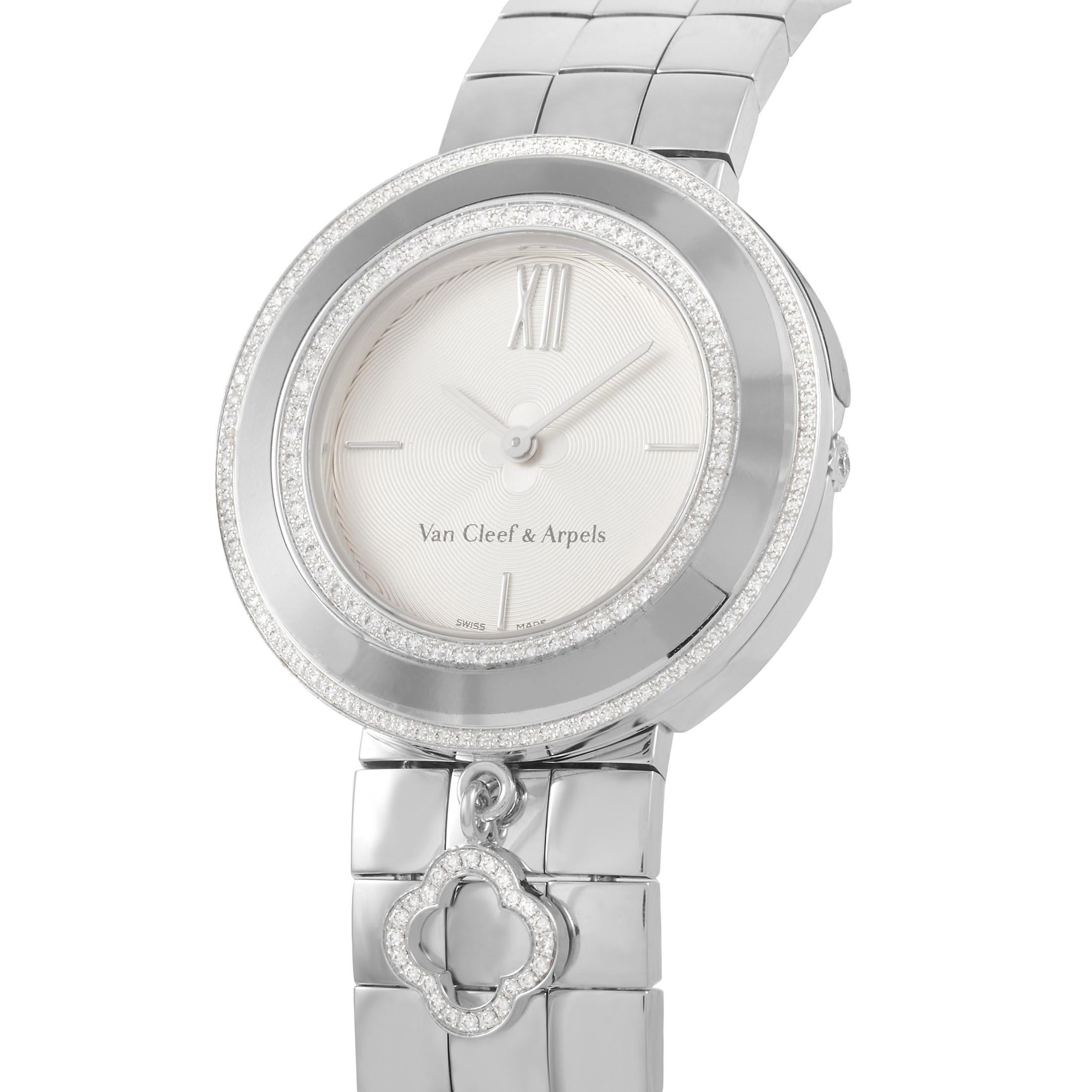 This Van Cleef & Arpels 18K White Gold Alhambra Charms Quartz Watch, reference number 3572114, features an 18K White Gold case measuring 32 mm in diameter. The bezel is set with two rows round diamonds, and features an Alhambra charm. It is