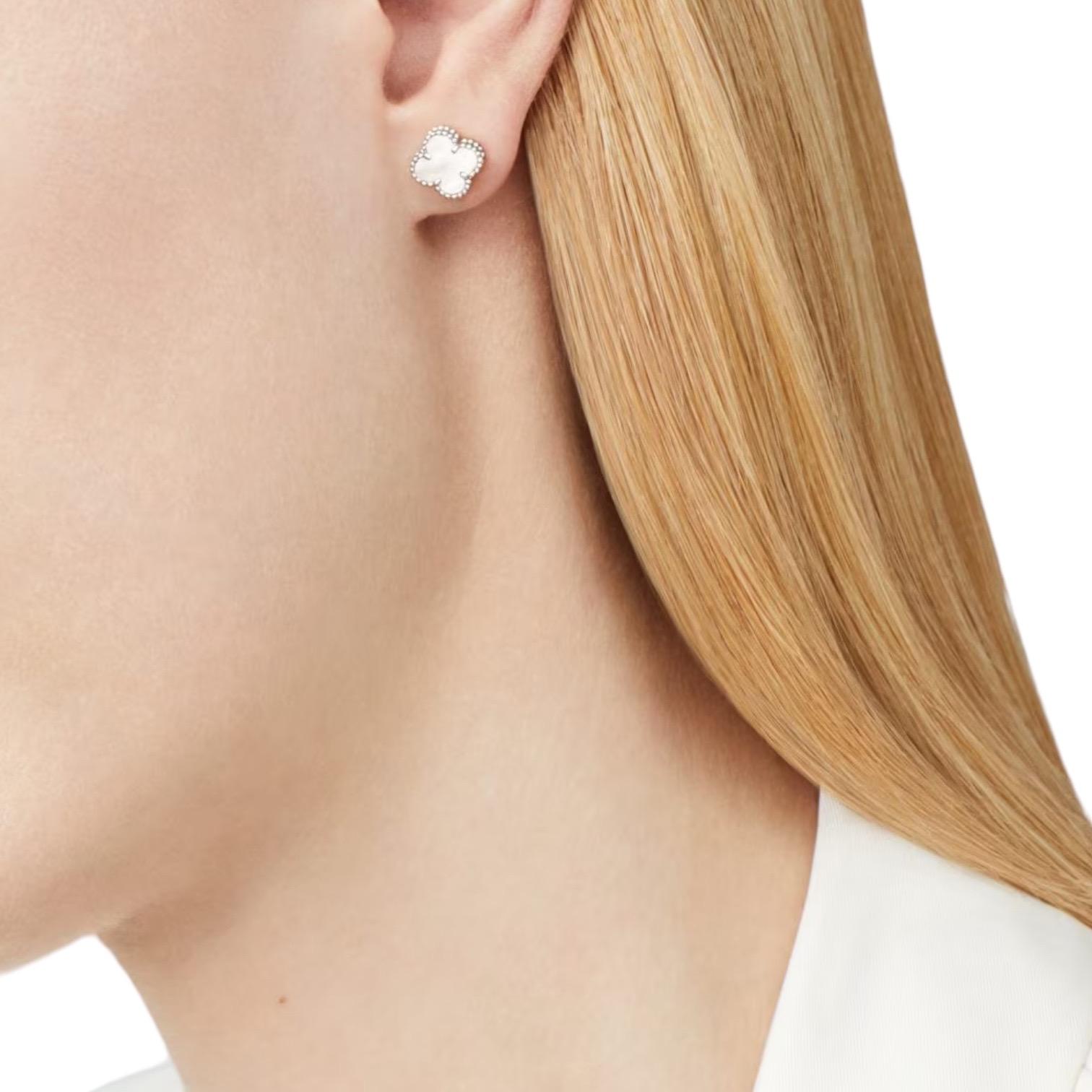 Experience pure elegance with our 'Lustrous Harmony' earstuds, a Van Cleef & Arpels creation crafted from 18k white gold. These sophisticated earstuds showcase the iconic clover design, inlaid with iridescent mother of pearl for a touch of serene