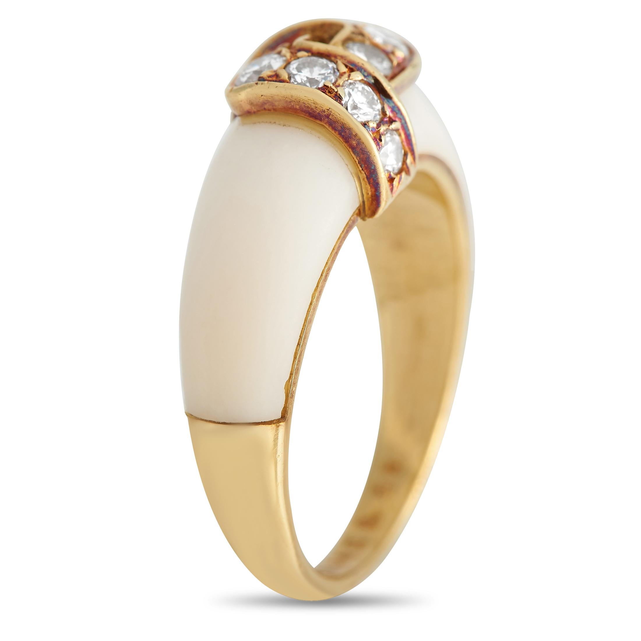 Questo Van Cleef & Arpels è un pezzo elegante, ideale da indossare tutti i giorni. Il corallo bianco ricopre la fascia in oro giallo 18 carati, che misura 4 mm di larghezza e 6 mm di altezza. Al centro, un'impressionante serie di diamanti