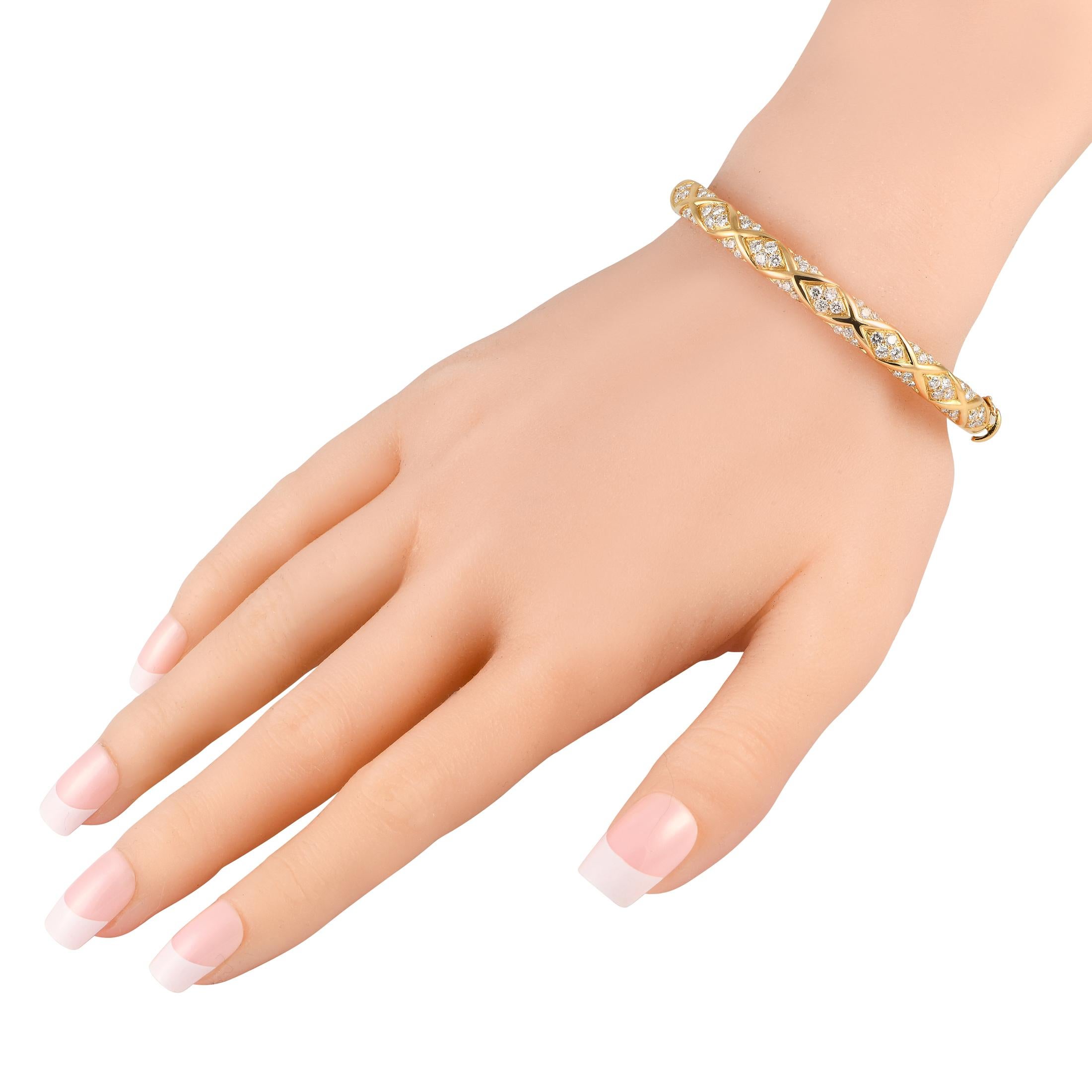 Chic and incredibly sophisticated, this Van Cleef & Arpels bracelet is poised to continually make a statement. An opulent 18K Yellow Gold setting beautifully highlights the sparkling Diamond accents totaling 1.80 carats. This bangle-style bracelet