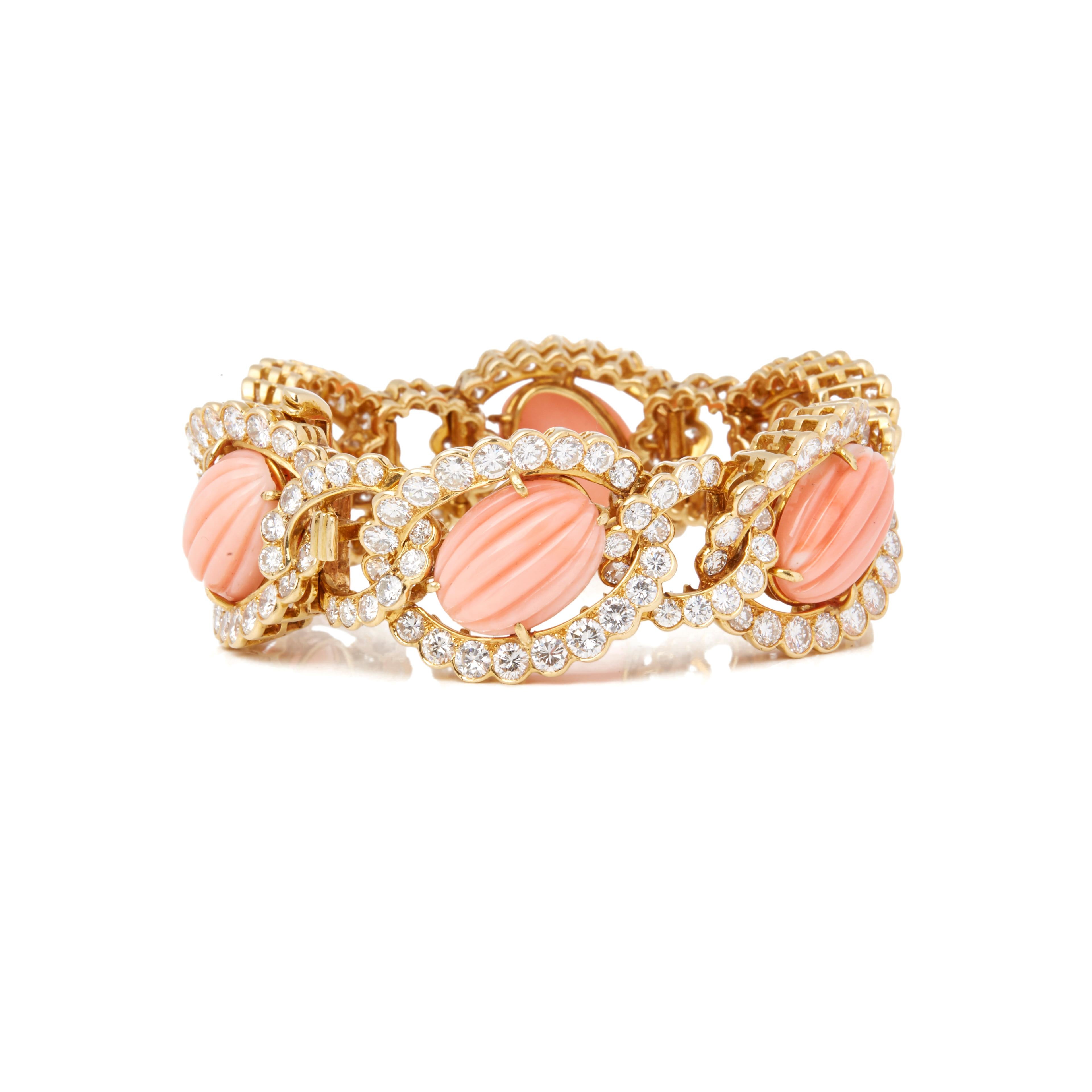 This Vintage Bracelet by Van Cleef and Arpels features One Hundred and Ninety Two Round Brilliant Cut Diamonds in Claw Setting with Scalloped Edge in an interlocking open setting surrounding Six Oval Cabochon Faceted Pink Corals in a Four Claw