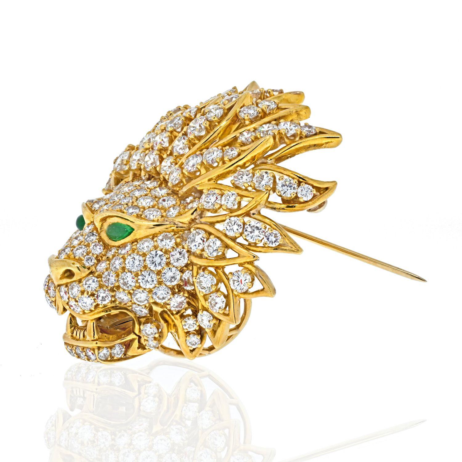 Lovely Van Cleef & Arpels diamond lion mask brooch. Made in 18K yellow gold, paved with round brilliant cut diamonds, and pear-shaped emerald eyes, signed Van Cleef & Arpels, numbered, with French assay and maker's mark.

