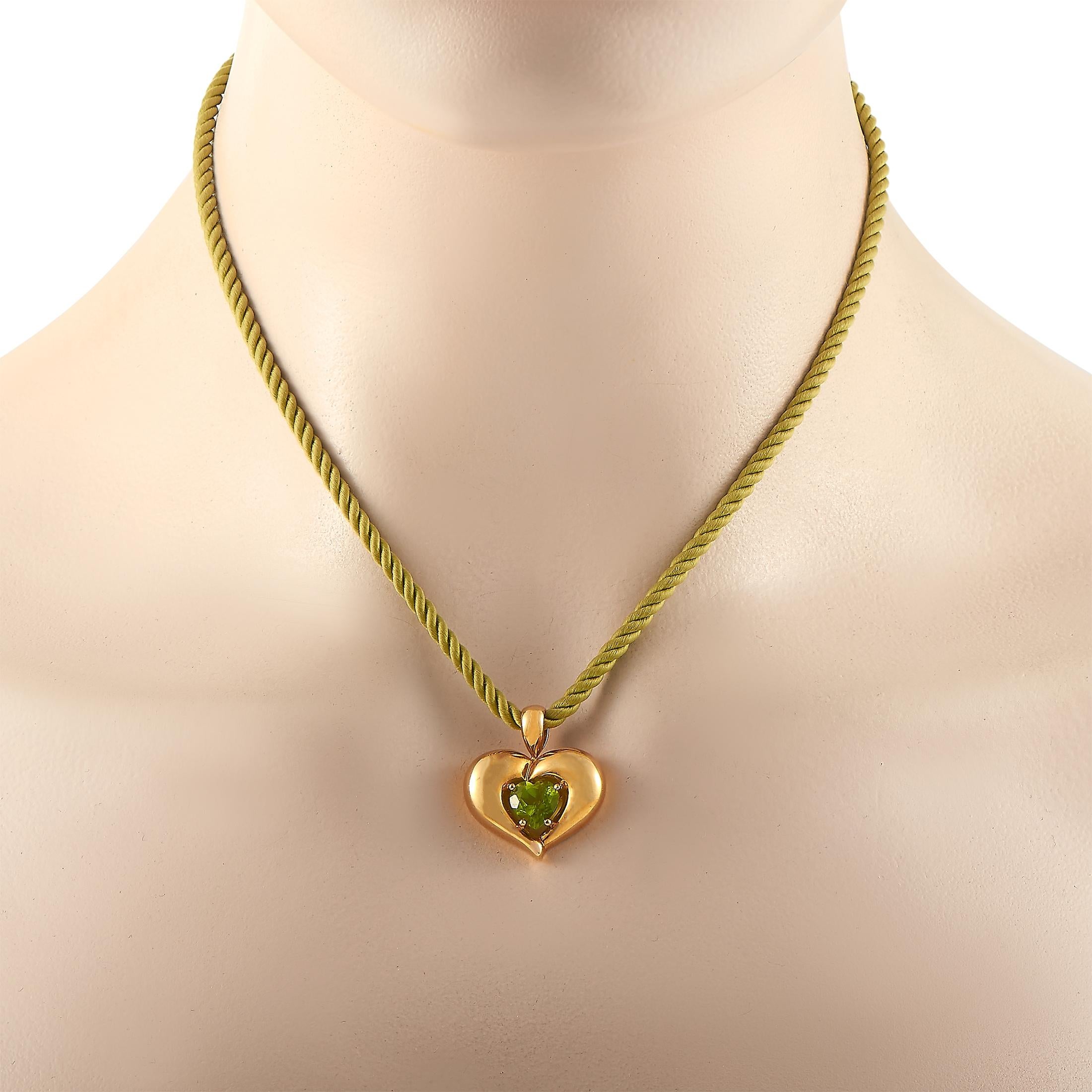This Van Cleef & Arpels necklace is presented with a green cord onto which a heart pendant is attached, made out of 18K yellow gold and heart-shaped peridot. The cord measures 16” in length and the pendant measures 1” by 1”. The necklace weighs 13.9