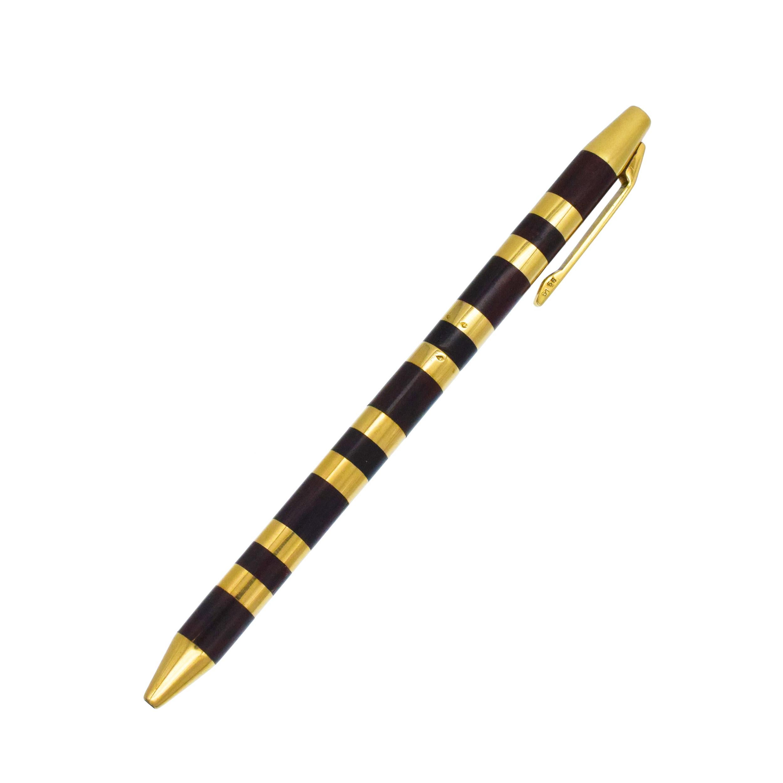 Van Cleef & Arpels 18k Gelbgold & Wood Stift. Diese
Der Kugelschreiber ist mit zwei separaten Tintenpatronen ausgestattet:
rot und schwarz. Das Streifendesign besteht aus abwechselnd goldenen und hölzernen Segmenten. Eingeschrieben: VCA, 750,