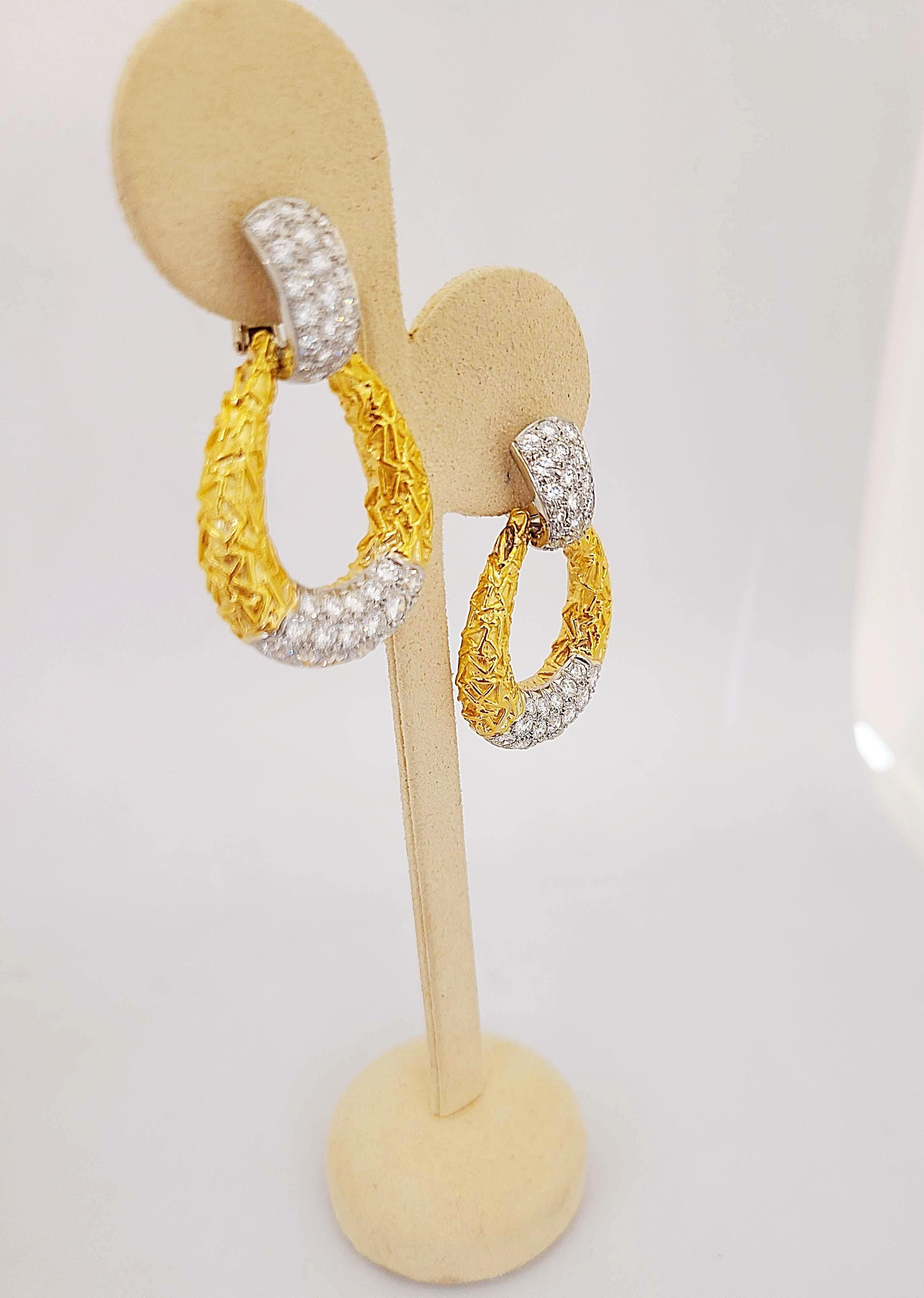 Crafted out of 18K yellow gold, composed of an articulated hoop, in a classic Chevalerie door knocker motif circa 1970, set with round-cut diamonds, weighing a total of approximately 5.55 carats, backs are clip-on; each earring measures 1-7/8 x