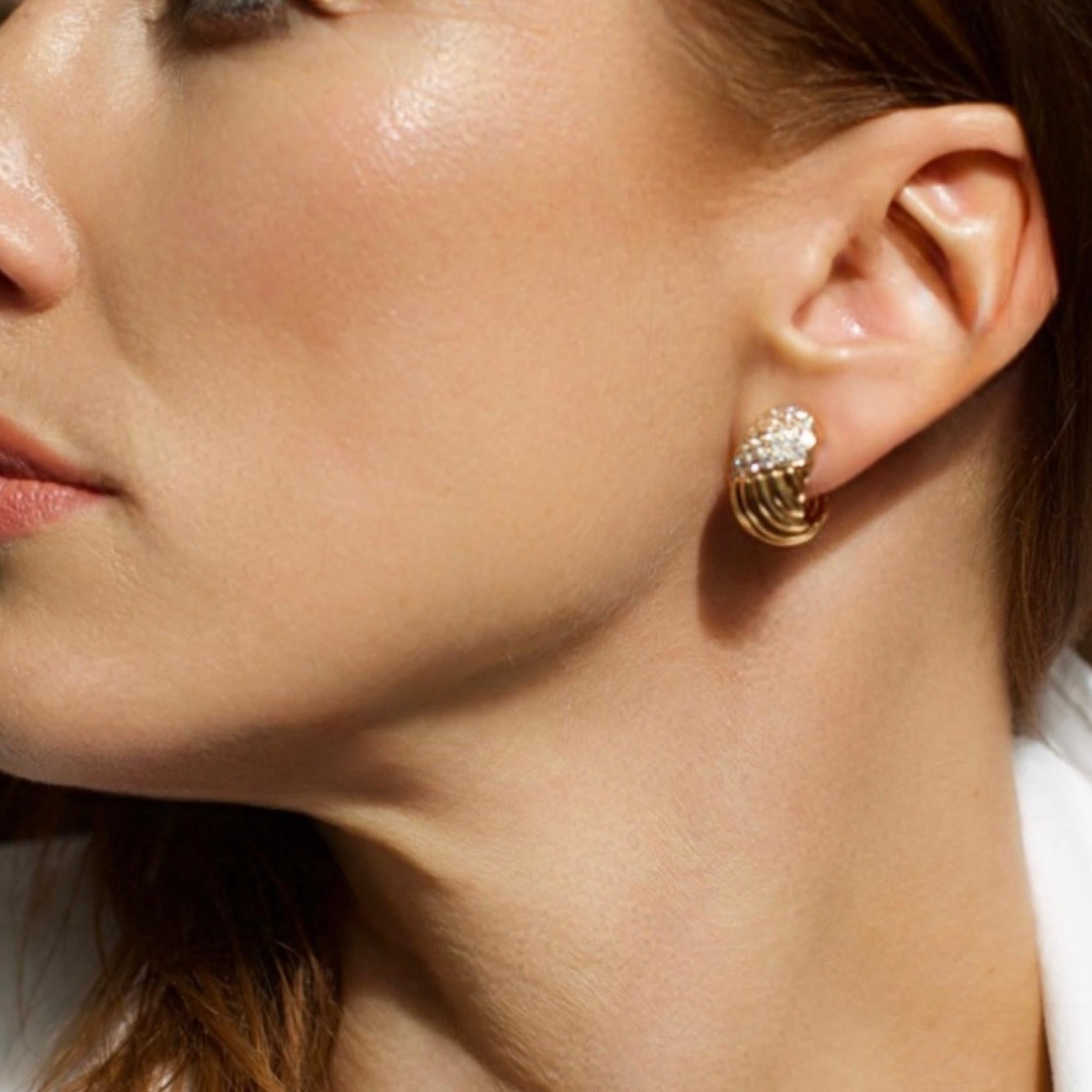 Un sorprendente paio di orecchini a clip vintage di Van Cleef & Arpels, realizzati in oro giallo 18 carati con un design a coste, con 52 diamanti rotondi taglio brillante incastonati. Risalenti alla fine del XX secolo, questi orecchini incarnano
