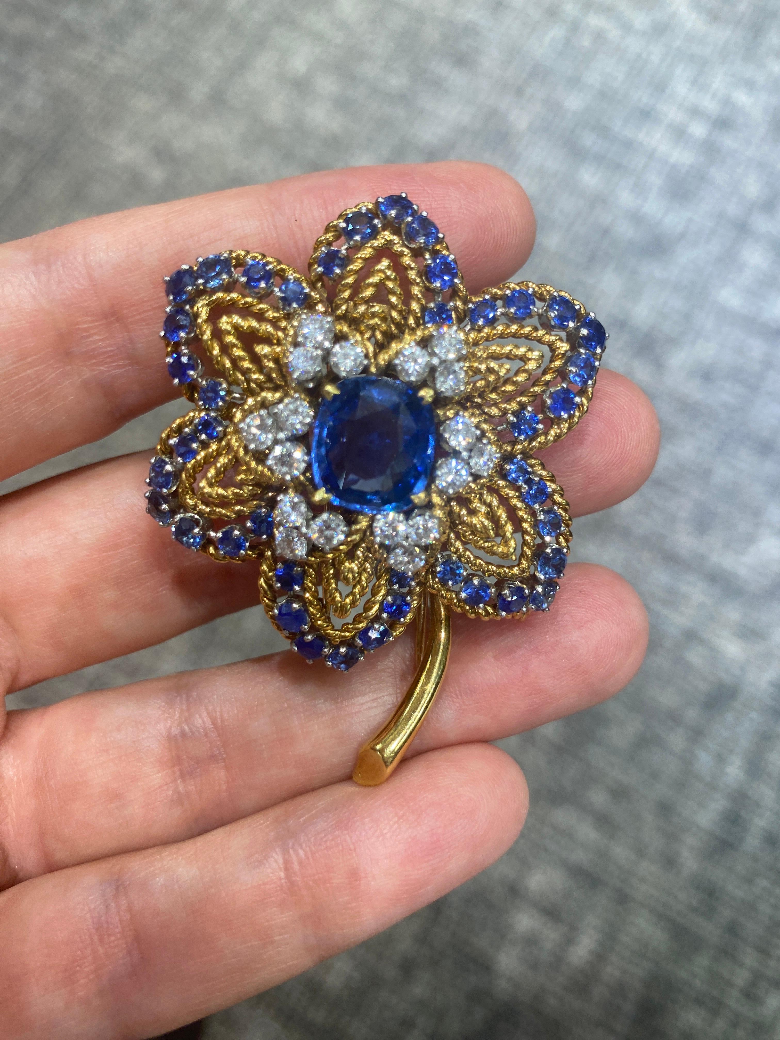 The design of this outstanding Van Cleef & Arpels 18 carat gold brooch from the 1960s centres around a 5.66 carat Ceylon sapphire. The centre stone is adorned with 18 round cut diamonds. The petals of the flower are outlined with round cut