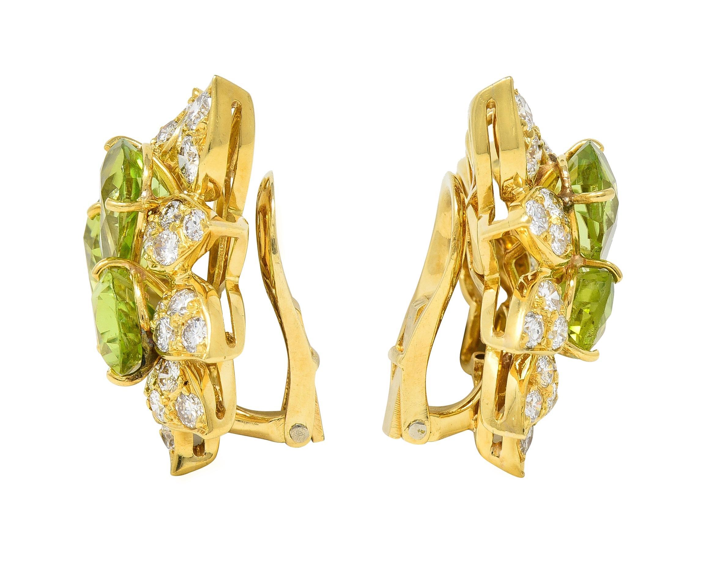 Centering clusters of pear-cut peridot weighing approximately 6.90 carats total
Transparent light yellowish green in color - prong set 
With a gold fanning foliate motif surround 
Bead set with round brilliant cut diamonds throughout 
Weighing