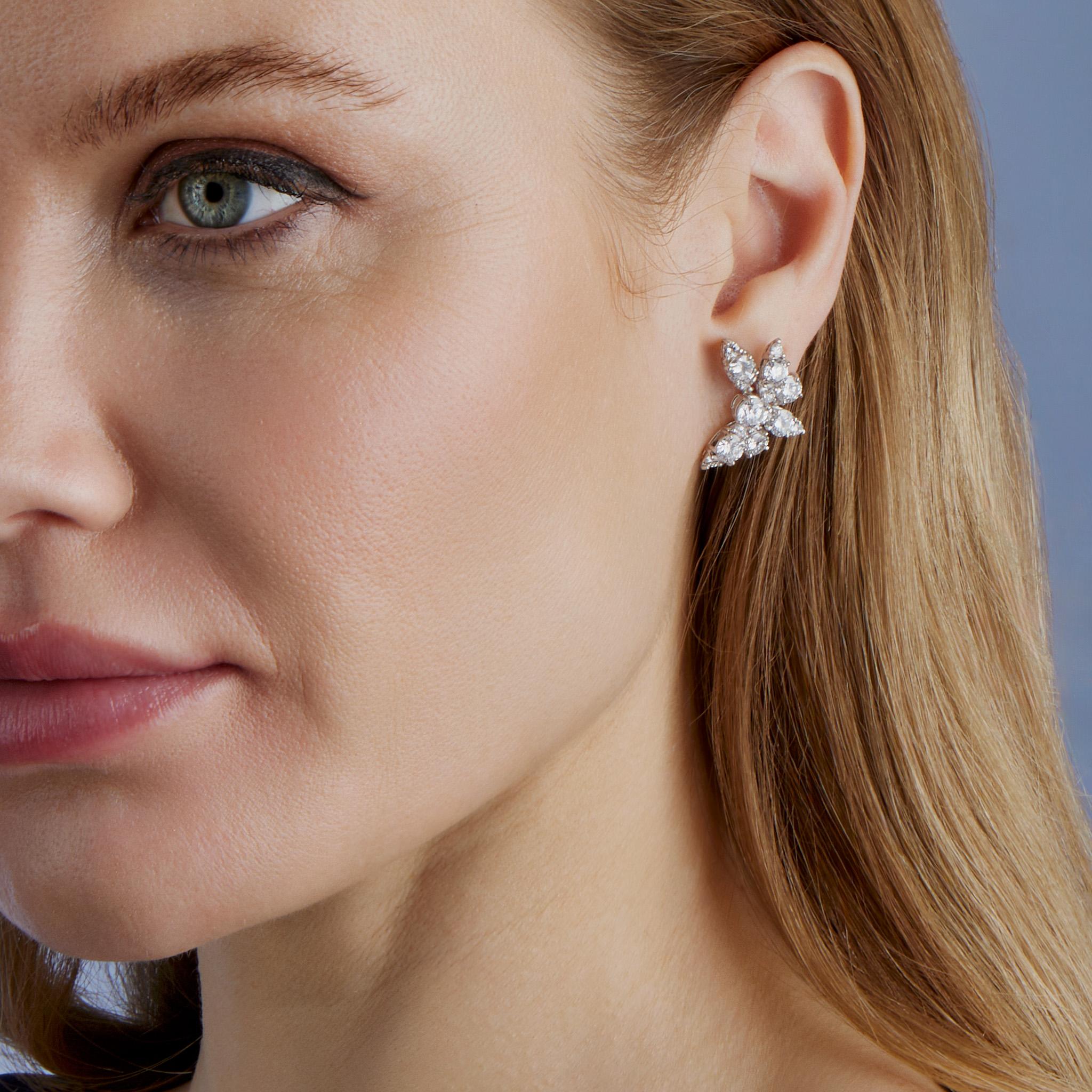 Diese in den 1960er Jahren kreierten Ohrringe von Van Cleef & Arpels bestehen aus Platin und ca. 7,00 Karat Diamanten. Jeder Ohrring mit Omega-Clipverschluss ist als Blüte gestaltet. Diese zierlichen, glänzenden Ohrringe wurden von den Juwelieren