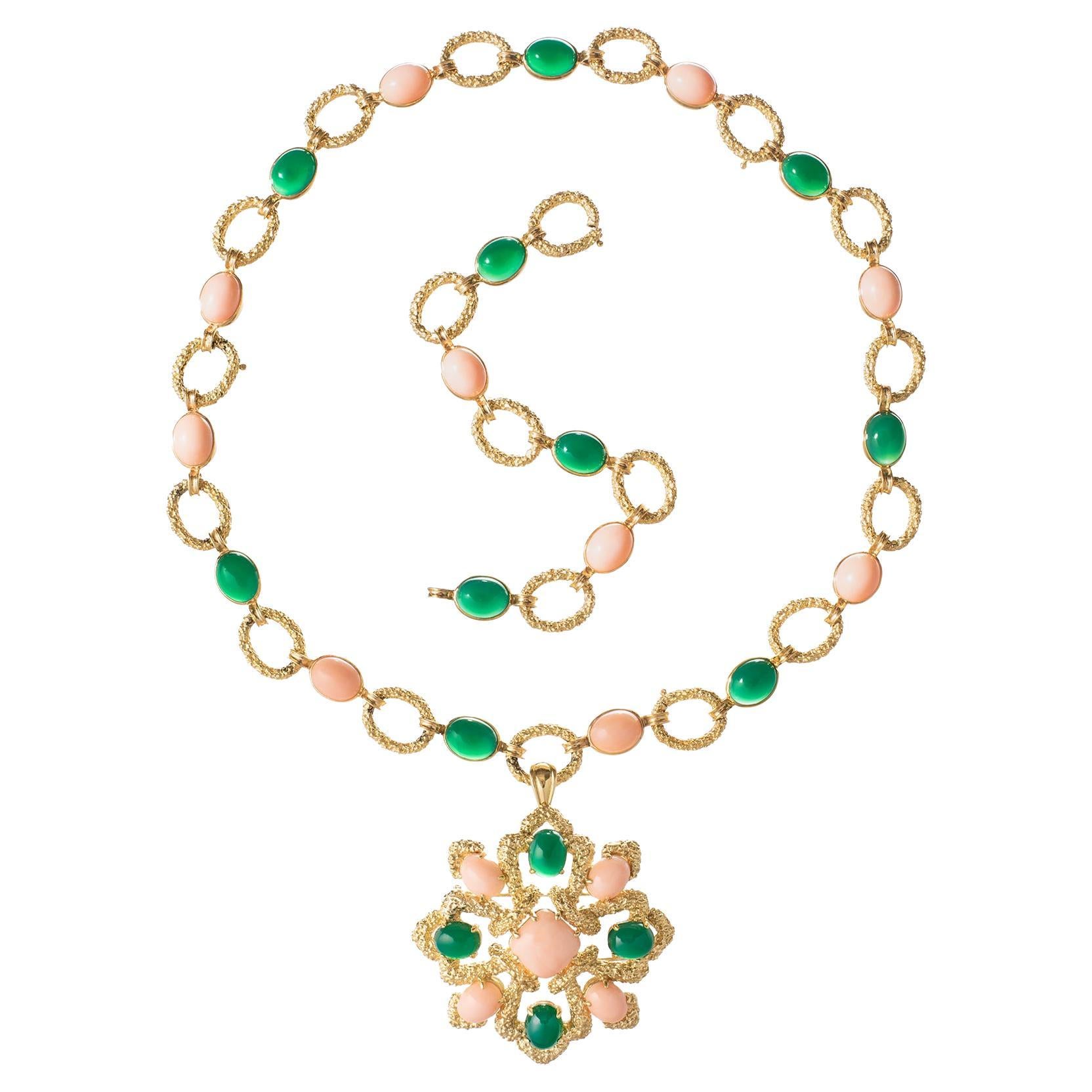 Van Cleef & Arpels 1970s Delphe convertible pendant necklace, composed of a long textured 18k yellow gold oval link chain necklace accented by alternating cabochon angel skin coral and chrysoprase, suspending a matching detachable pendant brooch. 