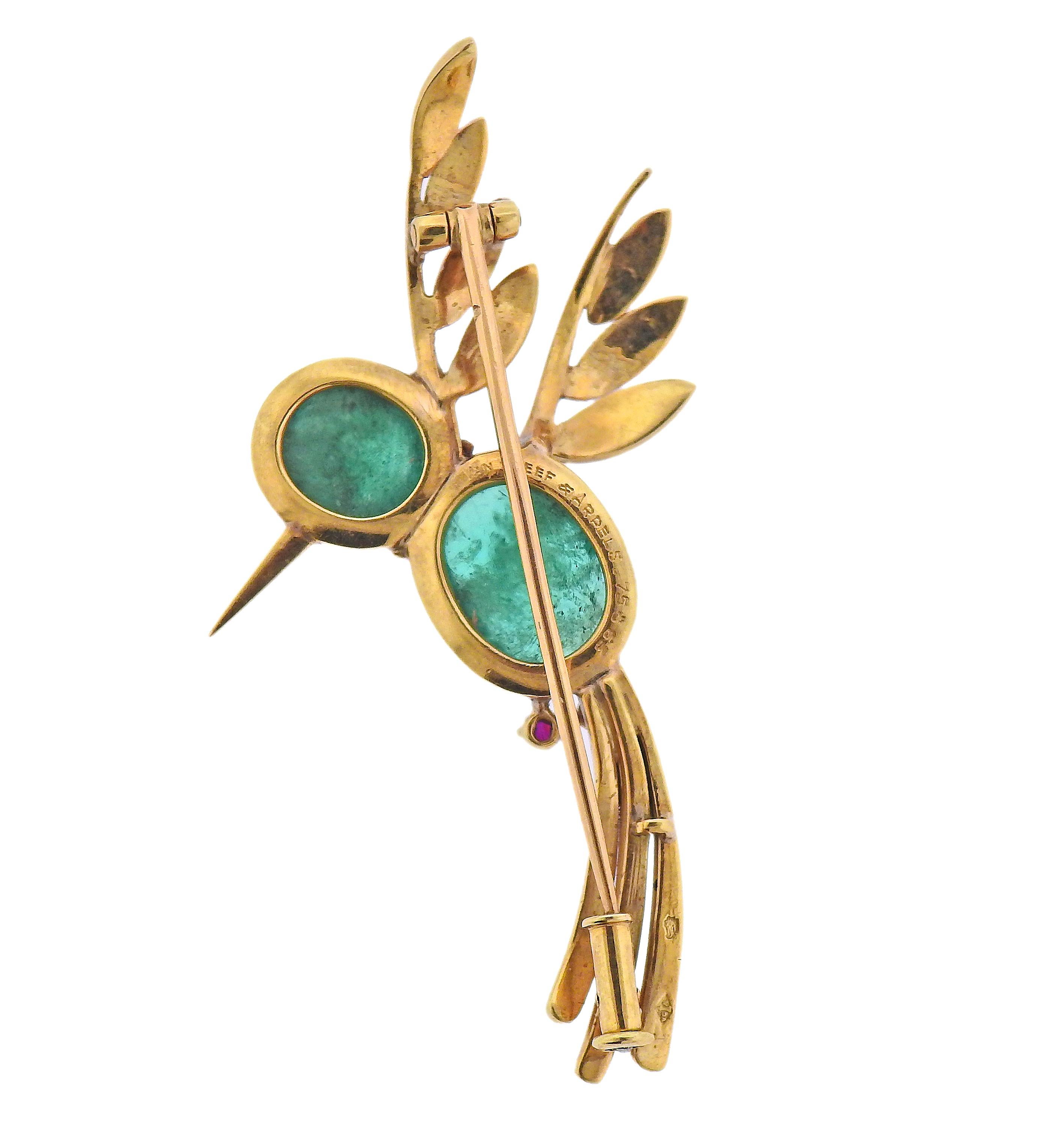 Adorable 18k gold hummingbird brooch by Van Cleef & Arpels, with two emerald cabochons (measuring 9 x 8.3mm and 12.3 x 9.3mm) ruby eye and two rubies on the tail. Brooch measures 55mm x 30mm. Marked: Van Cleef & Arpels, 75863. Weight - 11 grams. 