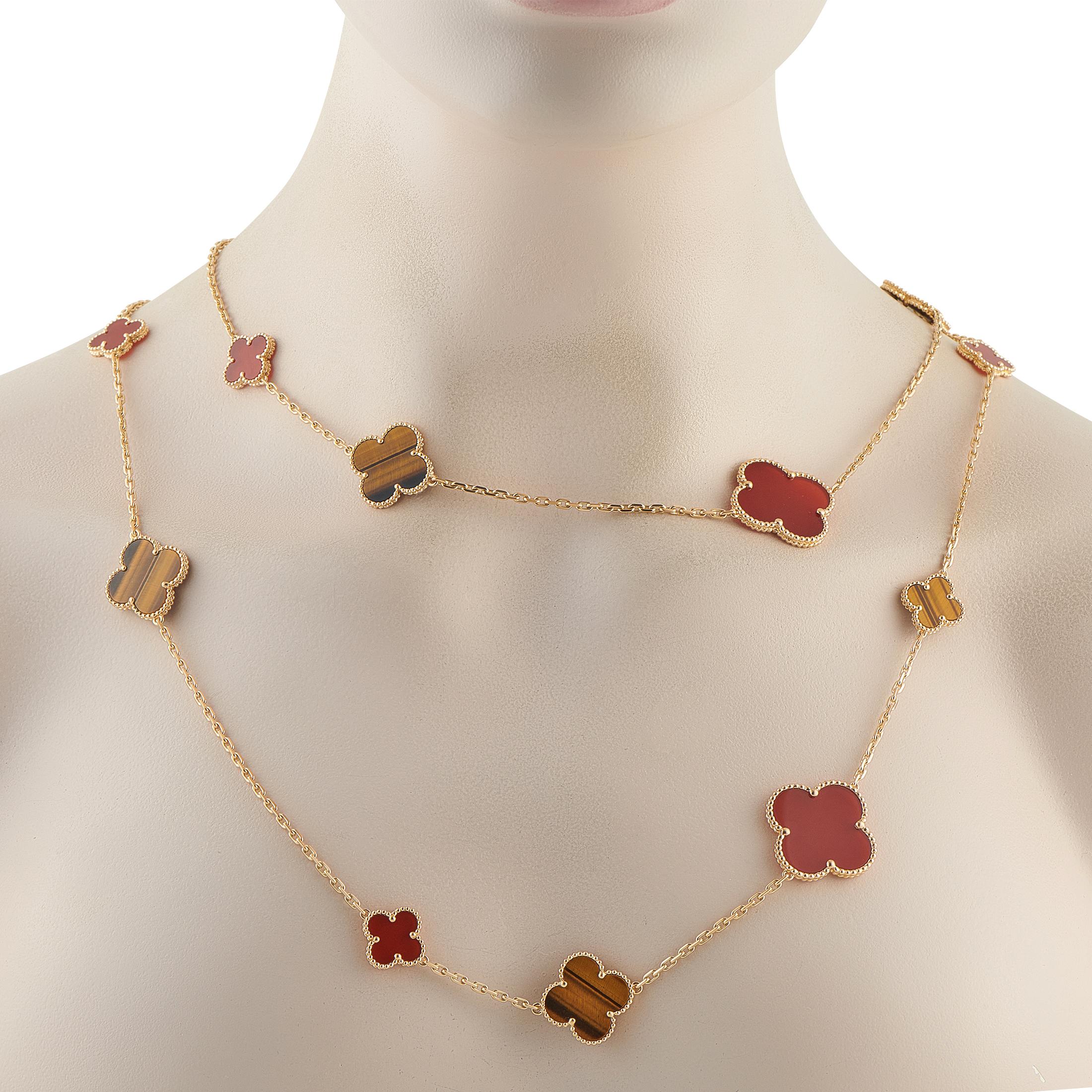 This Van Cleef & Arpels Alhambra necklace is a luxury piece that will continually captivate. Set in 18K Yellow Gold, 16 of the brands timeless clover motifs come to life in alternating Carnelian and Tigers Eye gemstones. It measures 48 long,