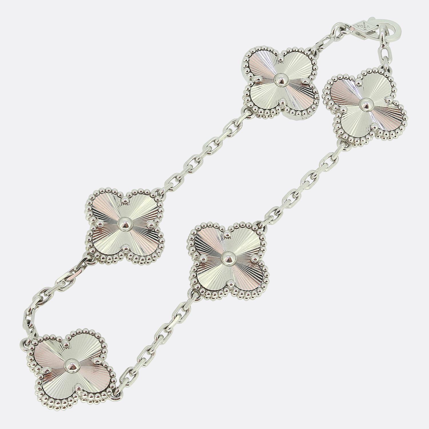 Hier haben wir ein ikonisches Armband aus dem weltbekannten Luxusschmuckhaus Van Cleef & Arpels. Dieses Armband ist Teil der Vintage Alhambra Collection und zeigt fünf Kleeblattmotive aus Weißgold mit einer Perleneinfassung und einer strukturierten