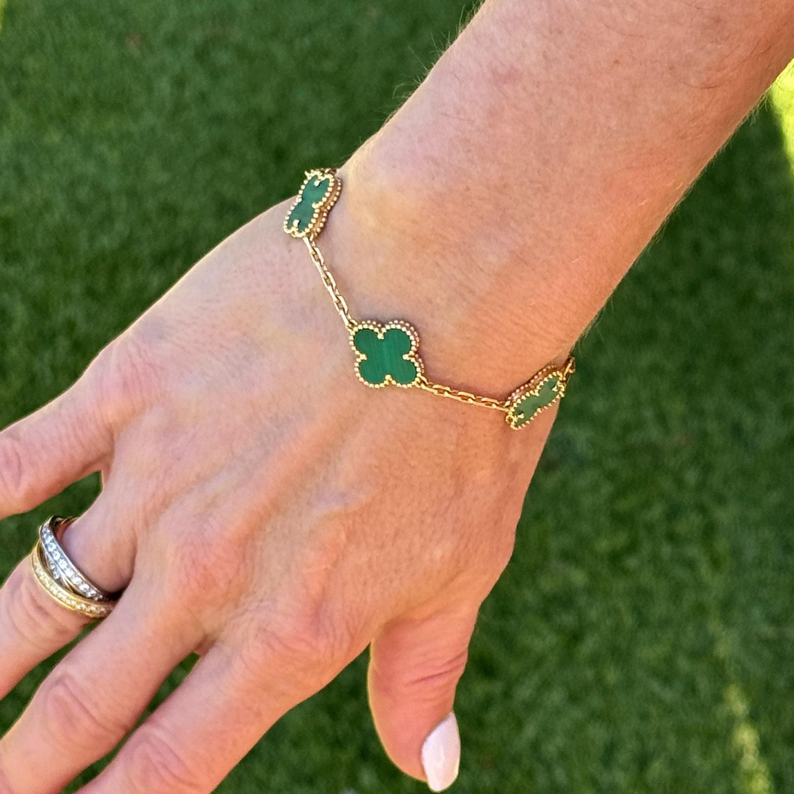 Dieses authentische Van Cleef & Arpels Malachit-Alhambra-Armband ist eine zeitlose Verkörperung von Eleganz und Handwerkskunst. Das Armband mit dem ikonischen Alhambra-Klee-Motiv zeigt fünf Stationen aus lebhaftem Malachit, die jeweils von einer