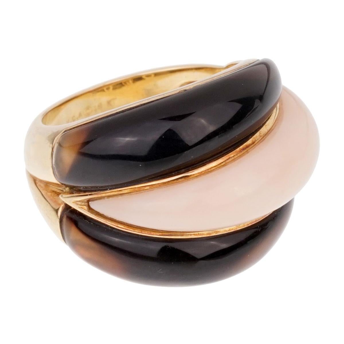 A magnificent Van Cleef & Arpels ring showcasing Angel Skin Coral and a very deep colored Smokey Quartz set in 18k yellow gold.

Size 5 (Resizeable)