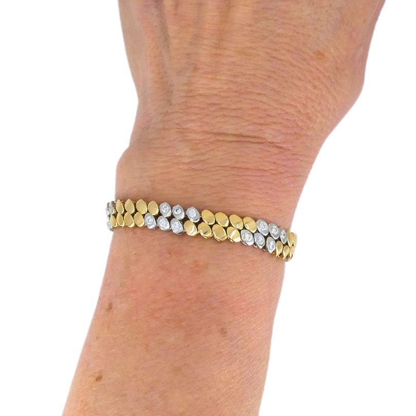 A refined Van Cleef & Arpels bezel set diamond bracelet crafted of 18k gold.
This VCA bracelet’s design alternates between warm yellow gold oval polished links and cool white gold oval polished links. Each white gold link is bezel-set with a round