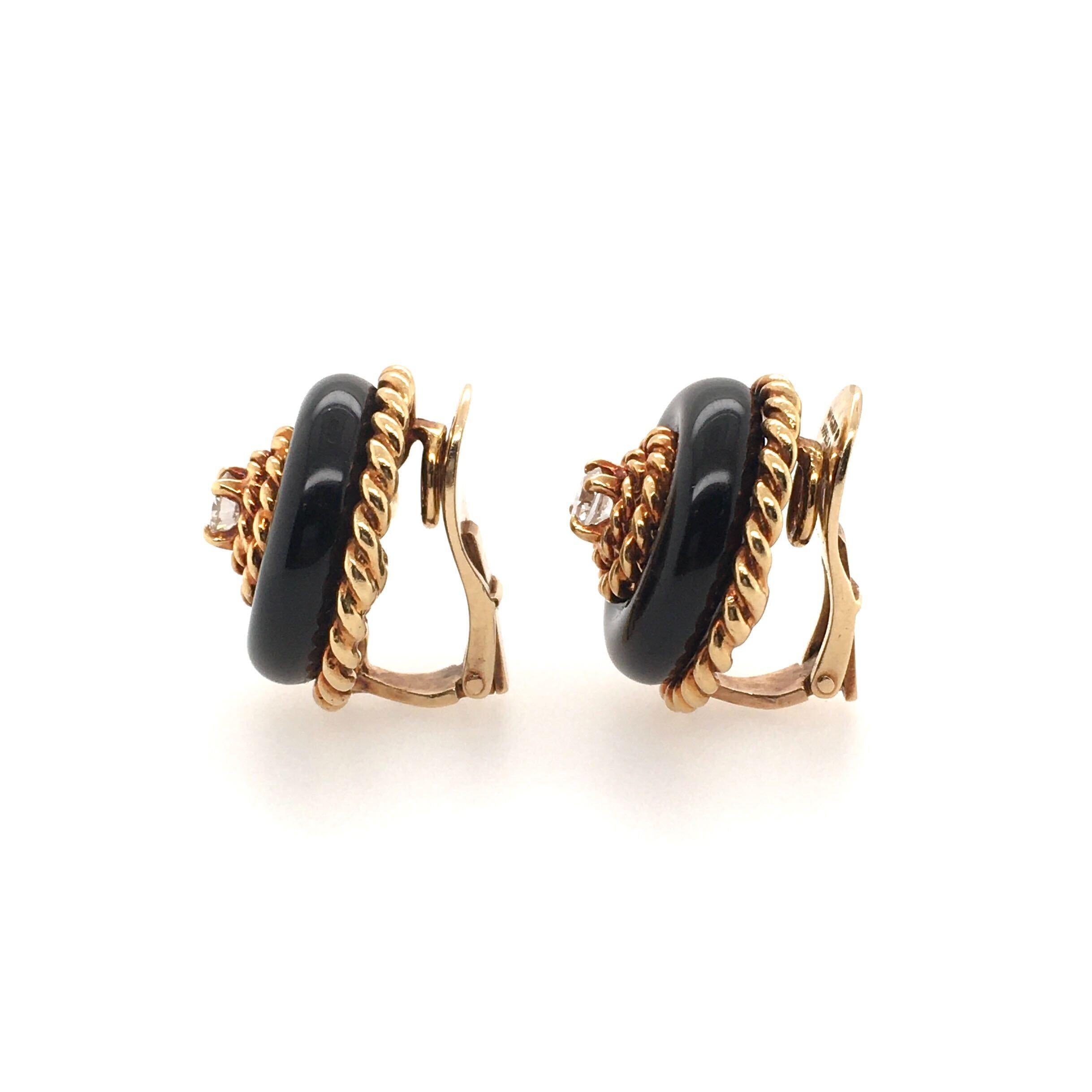 A pair of 18 karat yellow gold, black onyx and diamond earrings. Van Cleef and Arpels. Circa 1960. Of dome design, set with black onyx, enhanced by gold ropework, centering a circular cut diamond, each weighing approximately 0.20 carats. Diameter is