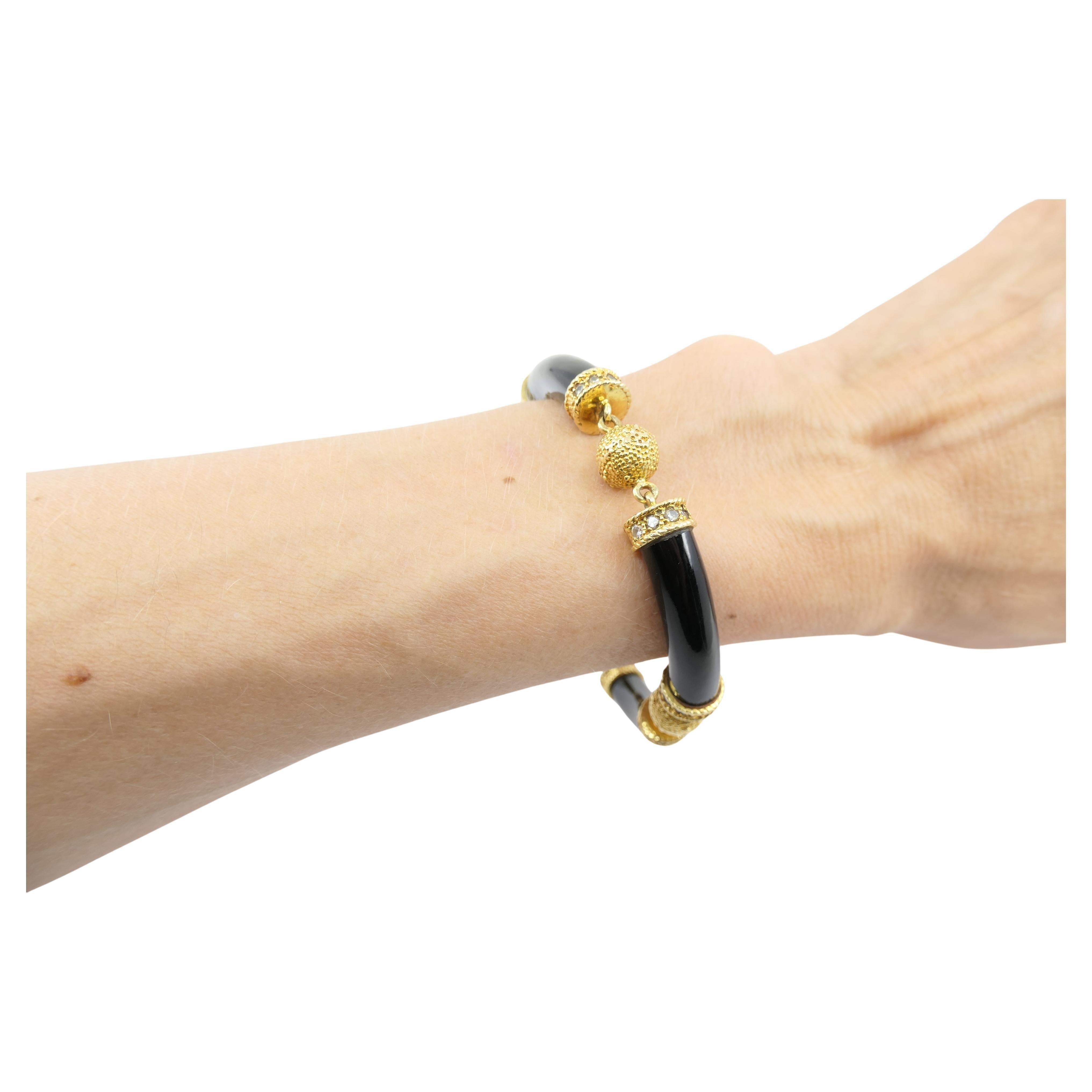 An exquisite Van Cleef & Arpels black onyx and gold bracelet, featuring diamonds; circa 1970s.
The bracelet consists of four black onyx links connected by four gold spheres. Each black onyx link, slightly curved, has two gold caps set on the ends