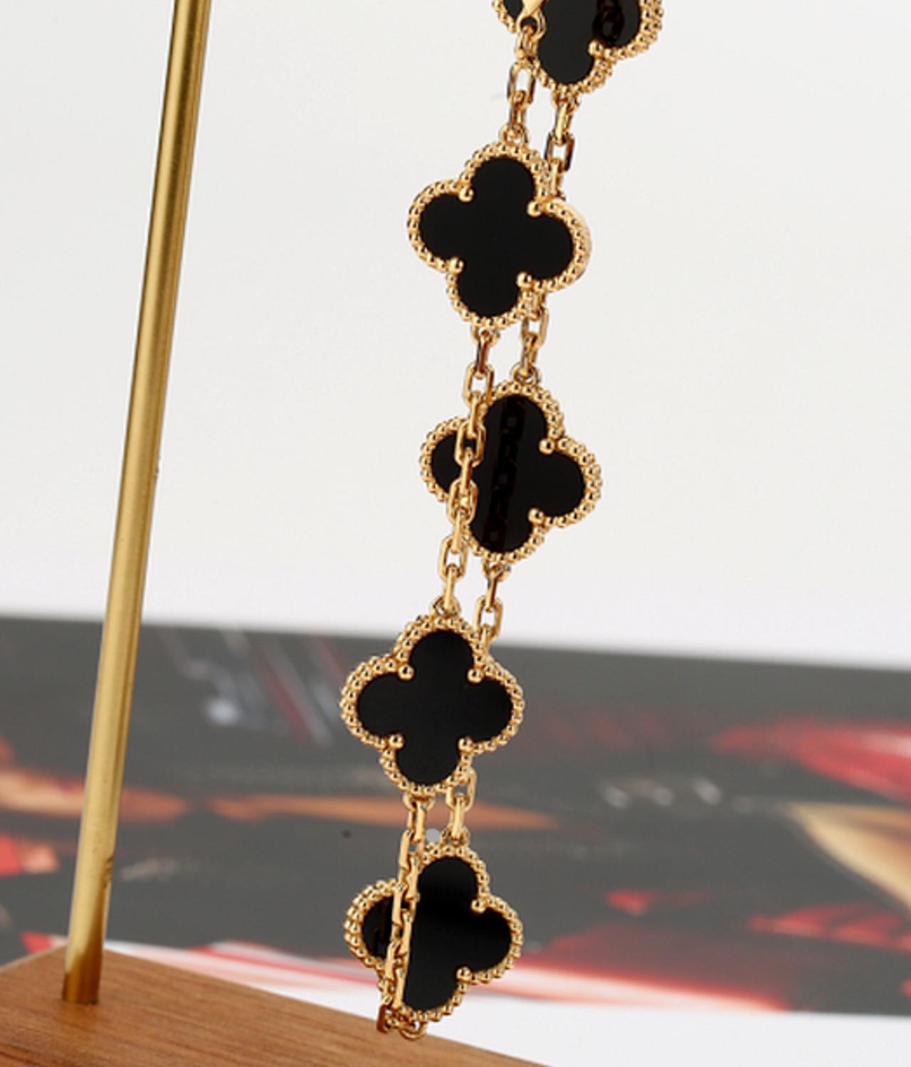 An 18k yellow gold bracelet from the Vintage Alhambra collection by Van Cleef and Arpels. The bracelet is made up of 5 iconic clover motifs, each set with a beaded edge and a black onyx inlay, set throughout the length of the chain.

The bracelet