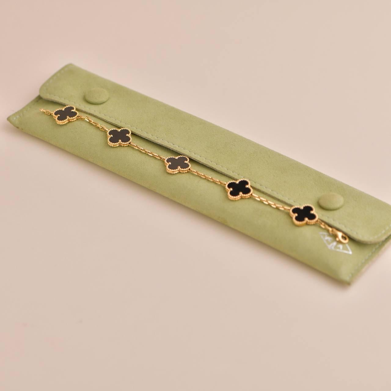 Bracciale in oro giallo 18 carati della collezione Vintage Alhambra di Van Cleef and Arpels. Il braccialetto è composto da 5 iconici motivi a trifoglio, ognuno dei quali è incastonato con un bordo di perline e un intarsio di onice nera, incastonato