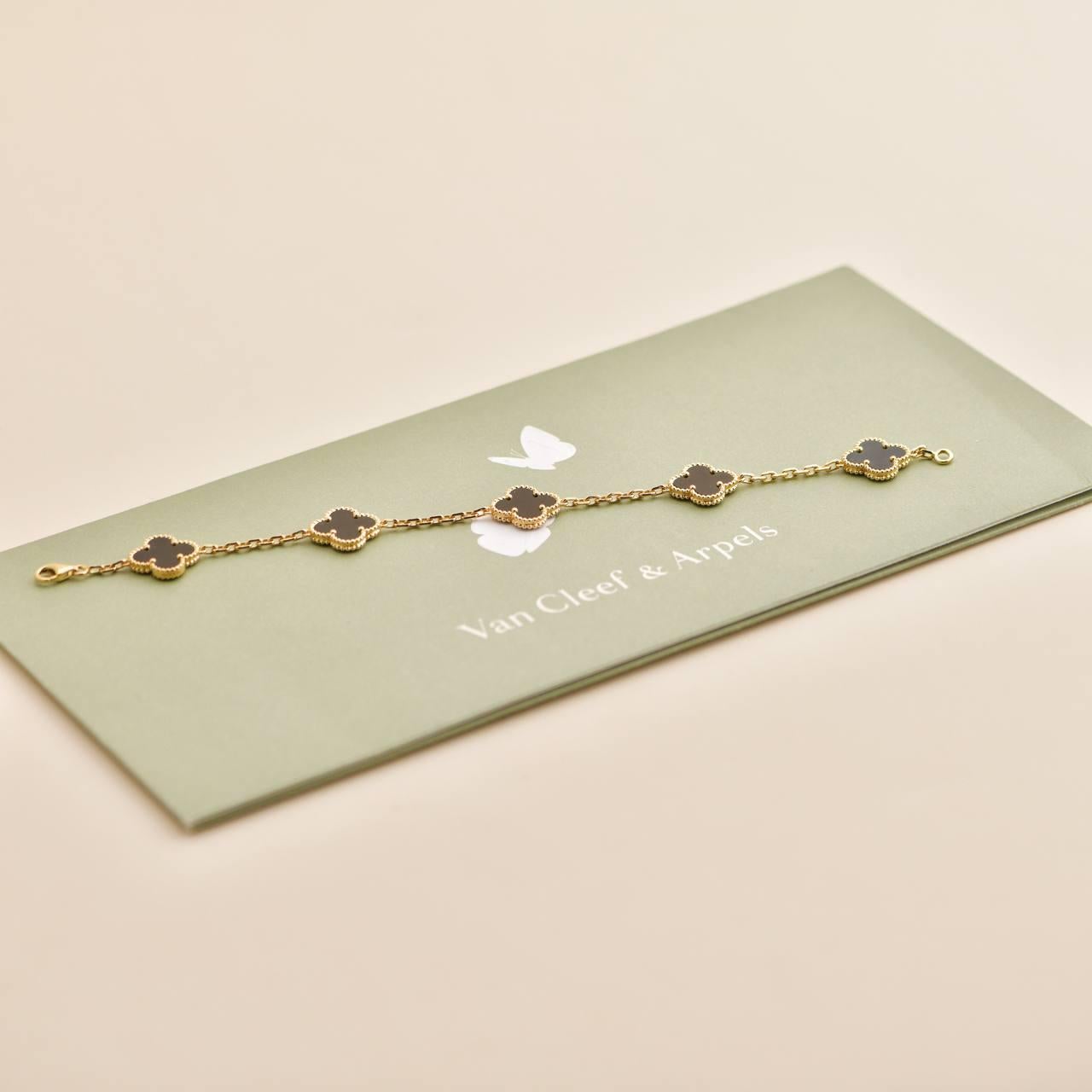 An 18k yellow gold bracelet from the Vintage Alhambra collection by Van Cleef and Arpels. The bracelet is made up of 5 iconic clover motifs, each set with a beaded edge and a black onyx inlay, set throughout the length of the chain.

SKU