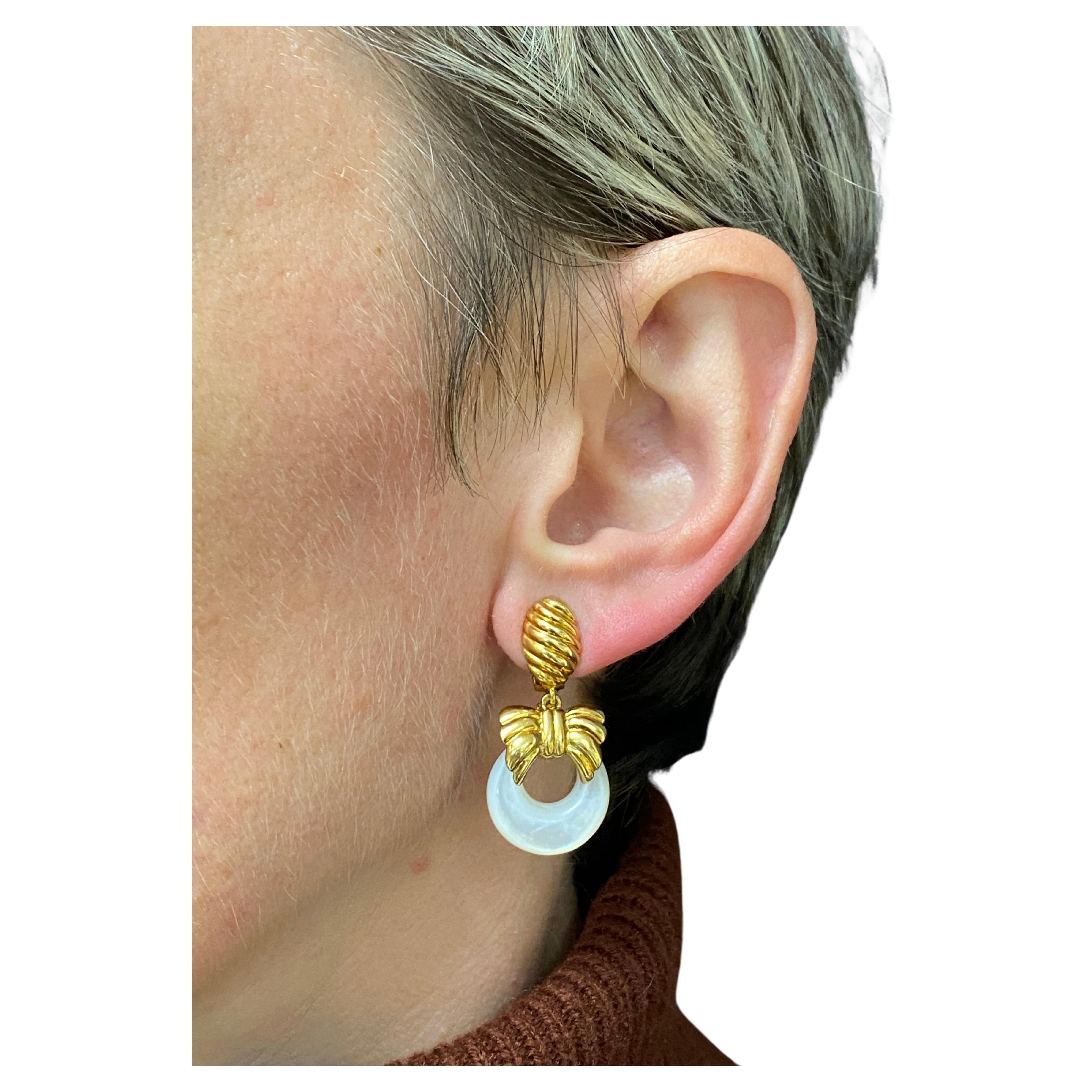 
A set of three interchangeable earrings by VCA, made of 18k gold, pearl, malachite and lapis lazuli. The earrings consist of the gold bow-shape element that holds a removable disk.  The disks are doorknocker shaped. High-polished and braded gold