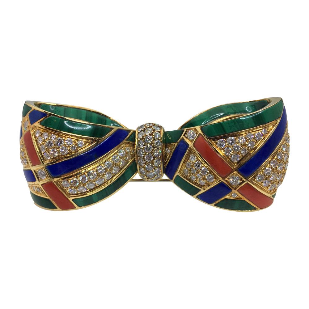 A colorful yellow gold Van Cleef & Arpels knot brooch set with diamonds, lapis lazuli, coral and malachite stripes.
Diamonds weight : approximately 3.50 carat.
Length : 66 mm.   Height : 24 mm.   Weight : 44.4 grams
It was sold with a Van Cleef and