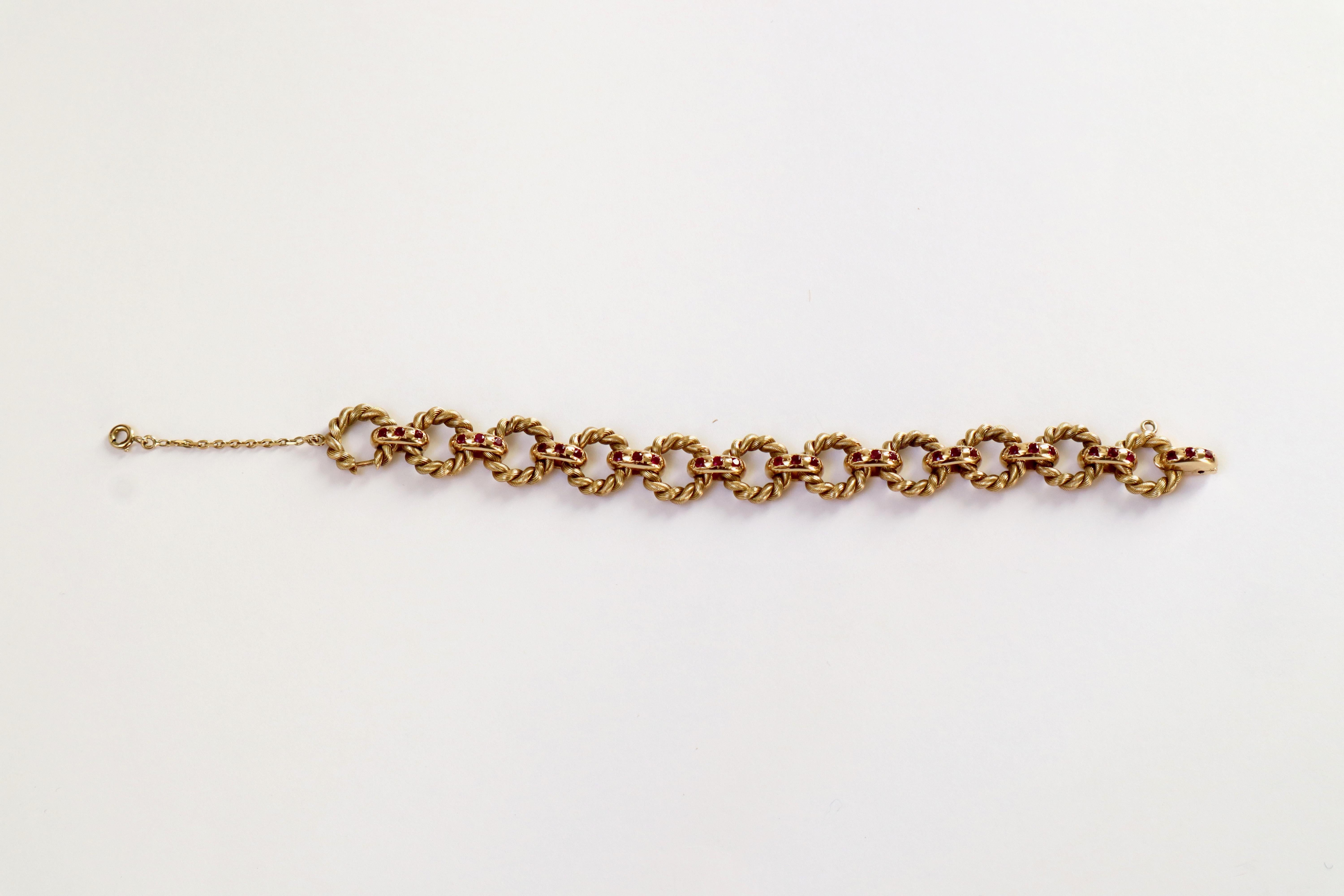 Bracelet Van Cleef & Arpels en or jaune 18 carats et rubis avec des anneaux torsadés
Bracelet composé de 11 anneaux torsadés retenus par 11 maillons sertis chacun de 3 rubis
Signé VCA et numéroté.
Fermeture du lien à l'extrémité s'ouvrant avec un