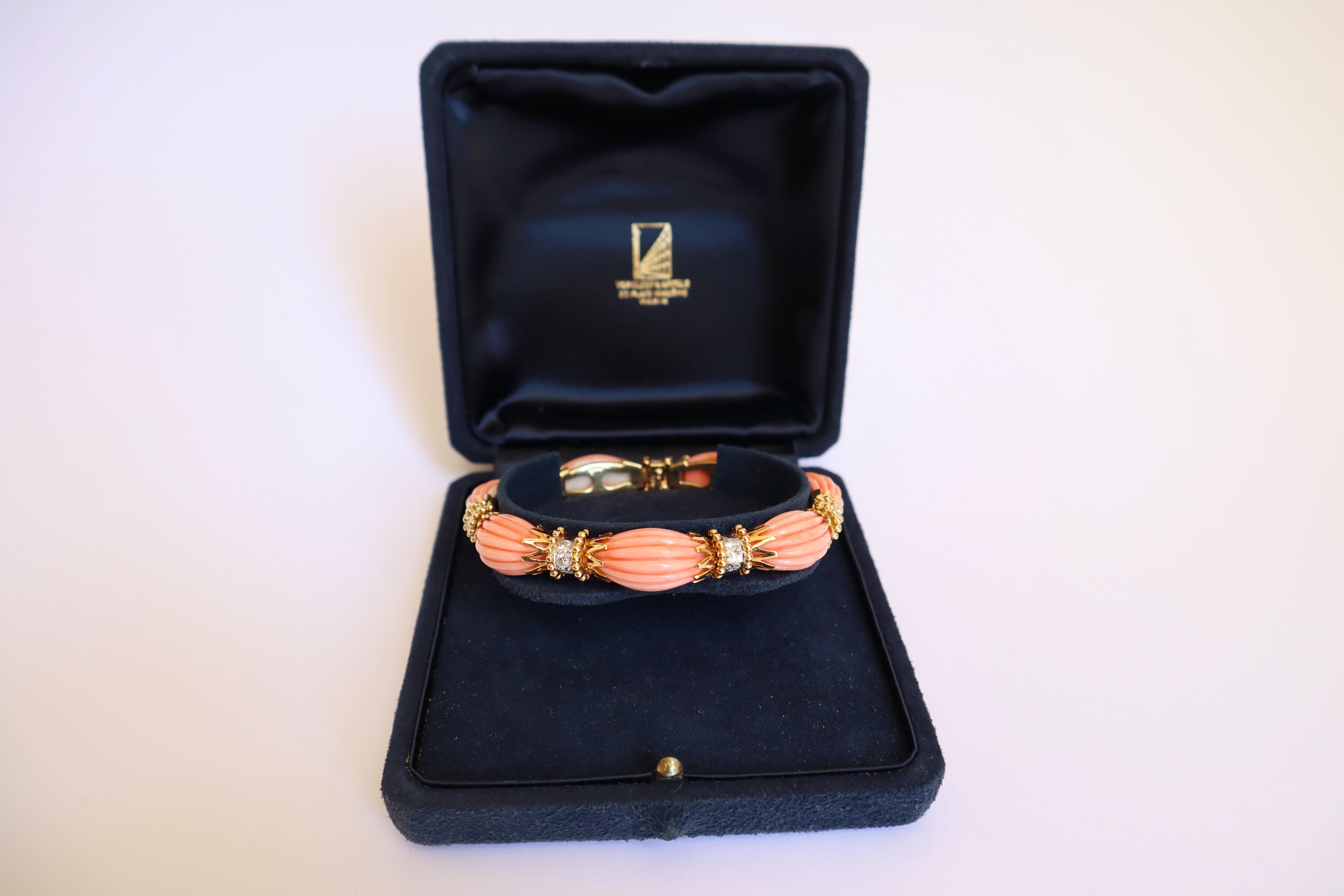 VAN CLEEF AND ARPELS Bracelet in 18 carat yellow gold (750mil.) and in platinum, with oval cabochons of gadrooned pink coral, held by 18 kt gold sleeves with pearl motifs, interspersed with platinum chevrons set with brilliant-cut diamonds.
7