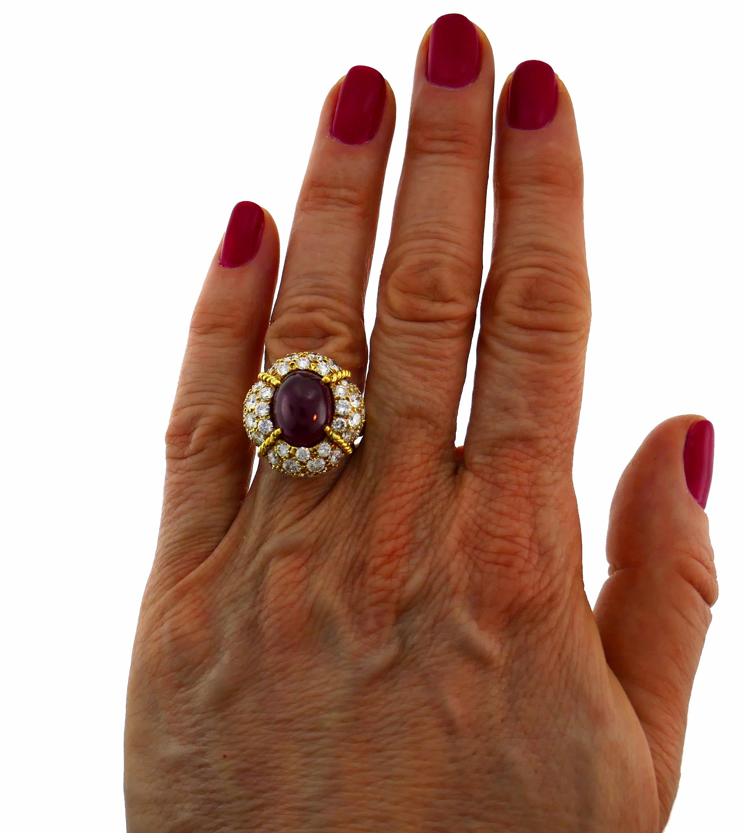 Stunning and chic cocktail ring created by Van Cleef & Arpels in France in 1985. Features an approximately 8.86-carat oval cabochon natural Burmese ruby set in yellow gold and framed with three rows of round brilliant cut diamonds (F-G color, VVS