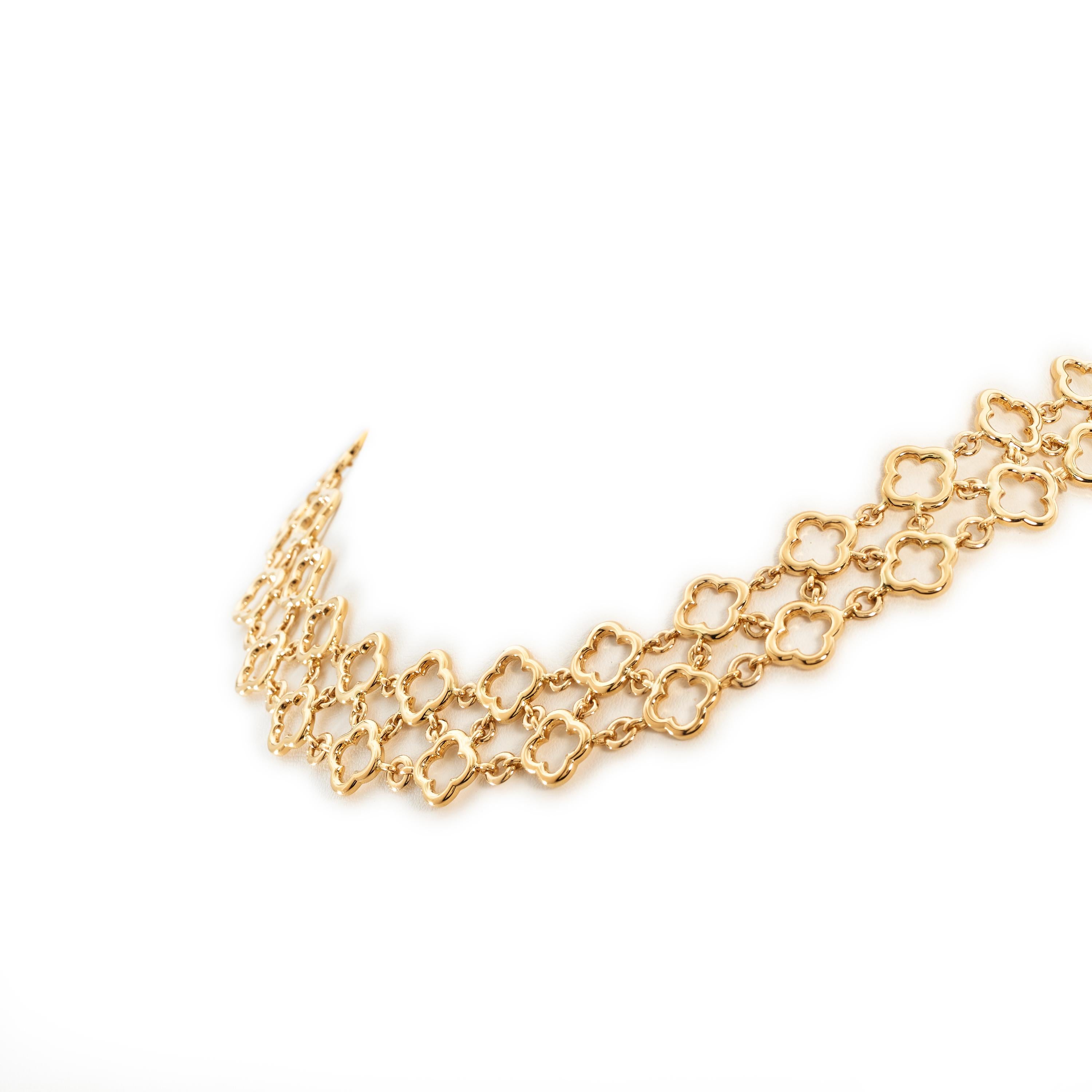 Authentic Van Cleef & Arpels Byzantine Alhambra necklace crafted in 18 karat yellow gold and featuring two rows of open work clover motifs, linked together in a woven pattern. The necklace measures 16 inches in length and approximately 3/4 inch in