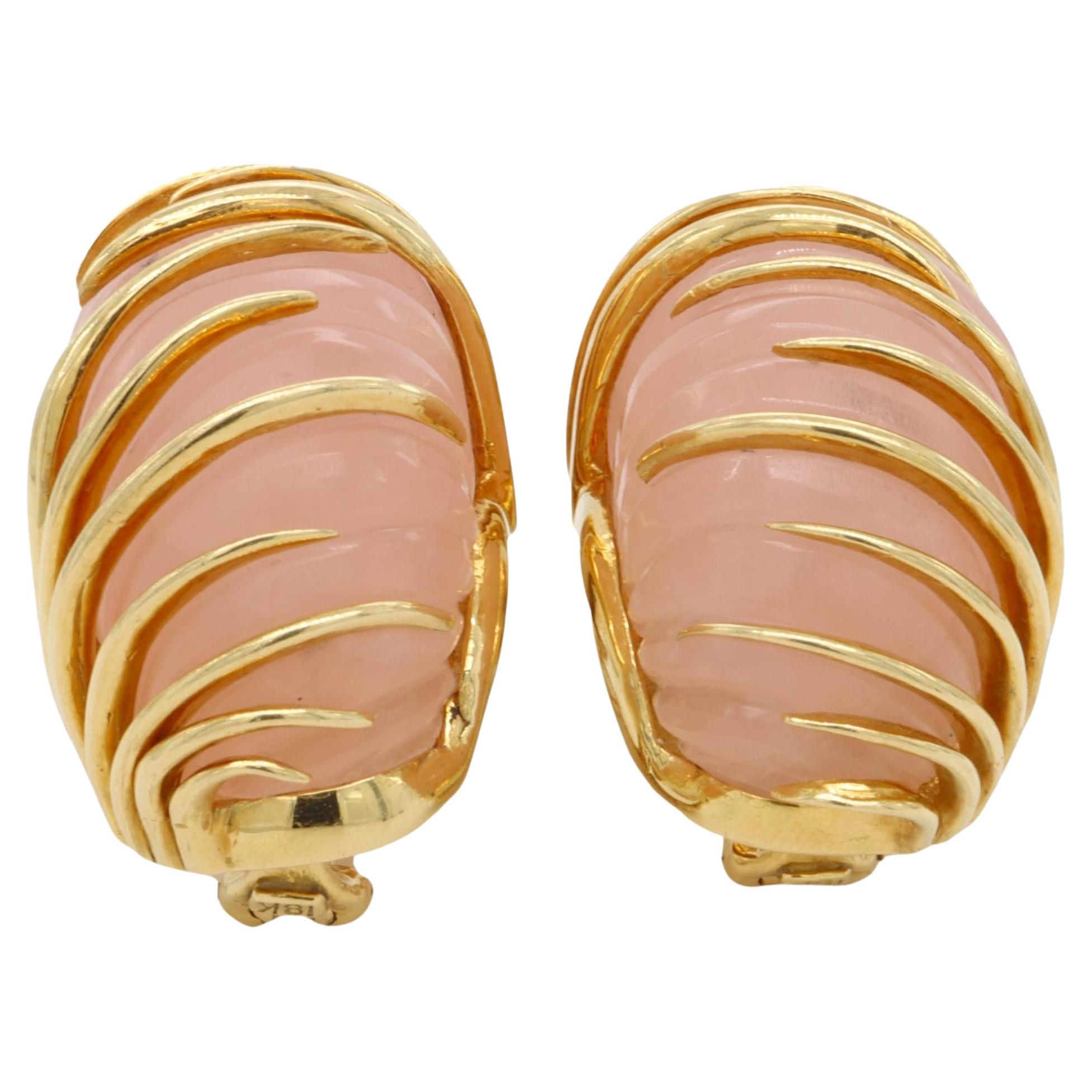 Pair of Vintage Van Cleef and Arpels earrings finely crafted in 18 karat yellow gold each featuring a carved rose quartz crystal encased by staggered tapered knife edge bands and Large Omega Clip Backs. Fully hallmarked with logo, serial numbers and