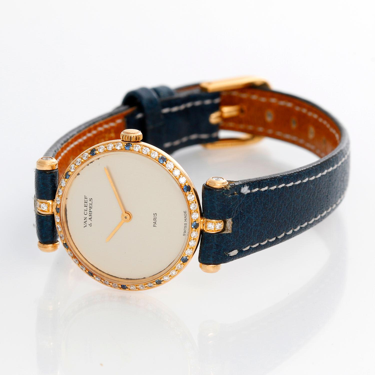 Van Cleef & Arpels Classic Yellow Gold Watch - Quartz. 18K Yellow gold with Diamond and Sapphire bezel ( 24 mm ). Silver dial. Blue leather strap with tang buckle. Pre-owned with custom box . 