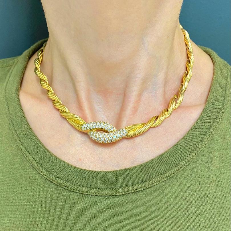 A Van Cleef & Arpels collar necklace, made of 18k gold, features diamonds. This sophisticated piece was crafted from swirling gold threads that form a beautifully flowing circular line. Round diamonds are set in the center, providing this VCA